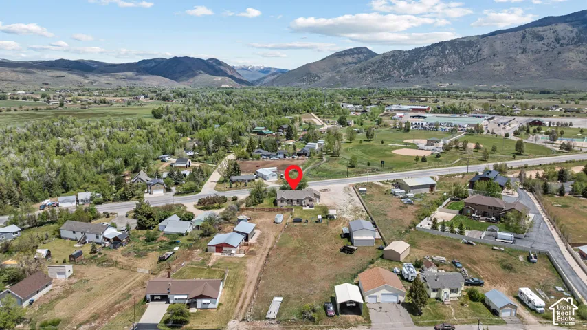 Expansive property featuring a single-story residence and detached garage, set against a backdrop of distant mountains