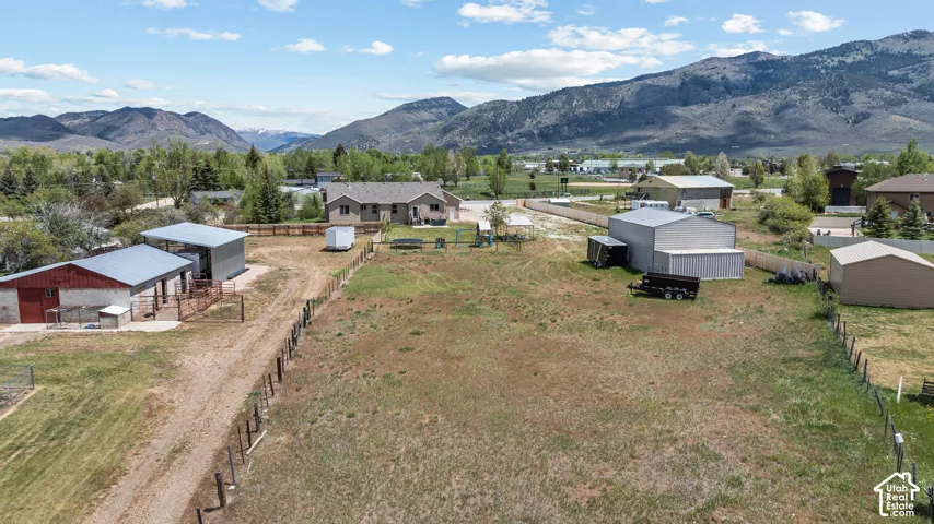 Expansive property featuring a main residence, multiple outbuildings, and mountain scenery