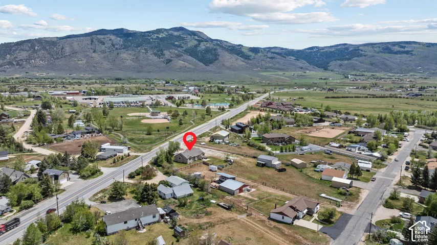 Expansive rural landscape featuring distant mountains and a valley with scattered residential properties