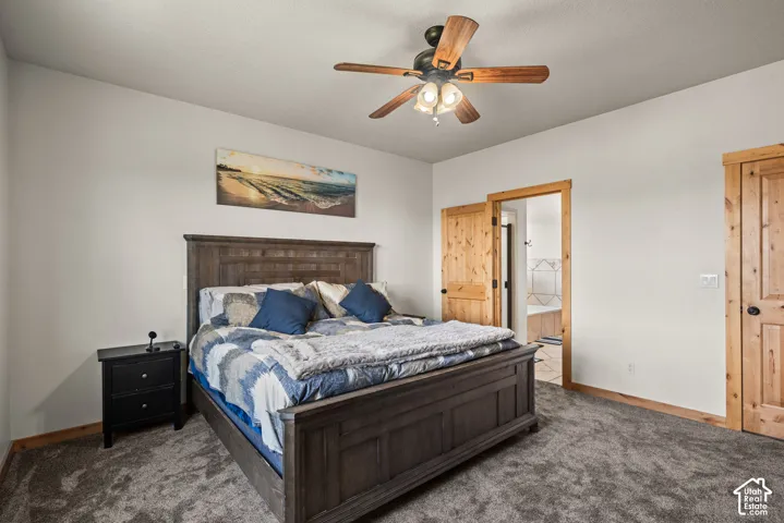 Bedroom featuring plush carpeting, light-toned walls, and wood-trim accents