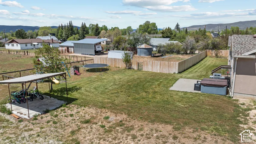 Expansive backyard featuring a manicured lawn, a concrete patio, and a privacy fence