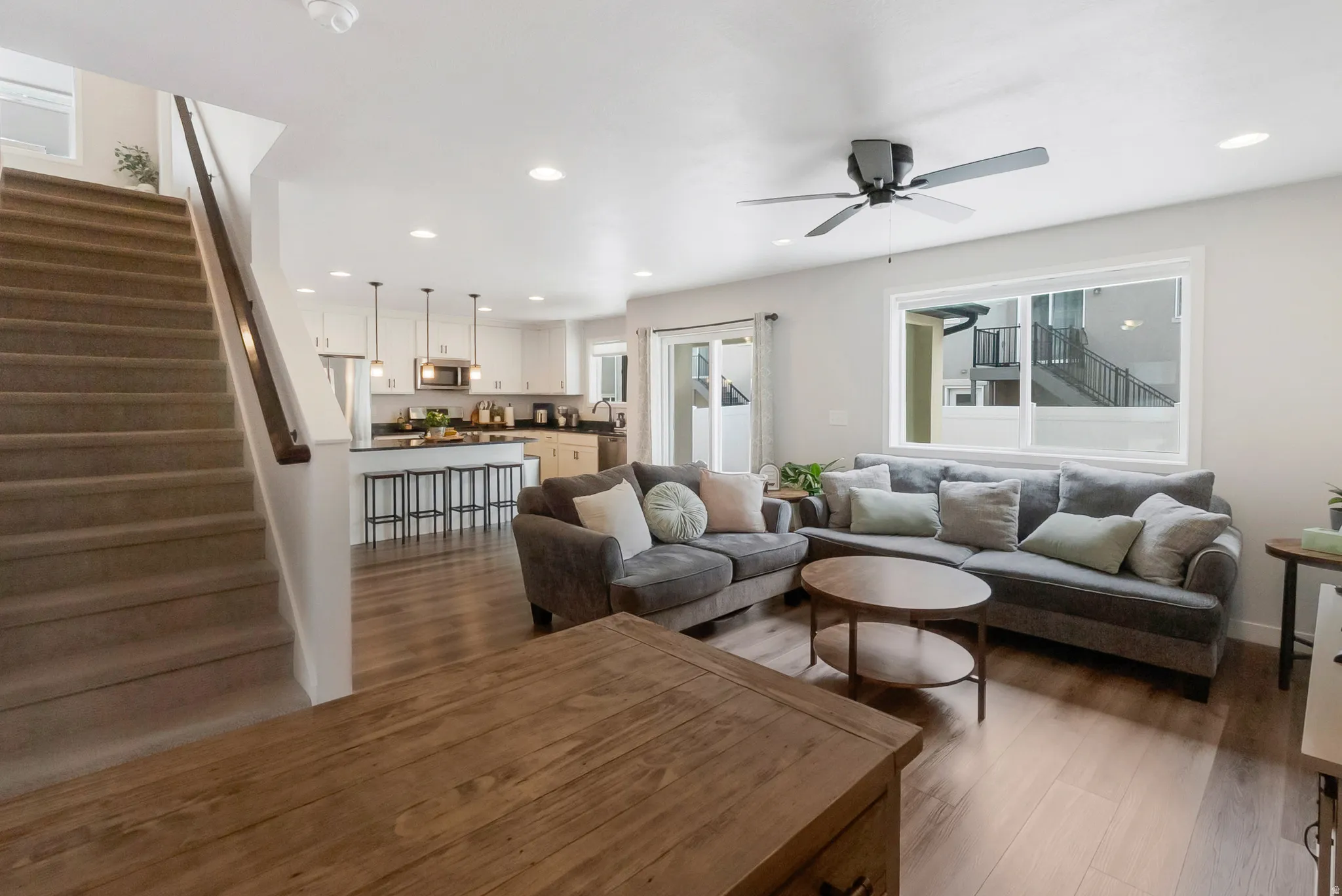 Open-concept living space featuring wood-finish flooring, recessed lighting, and a ceiling fan