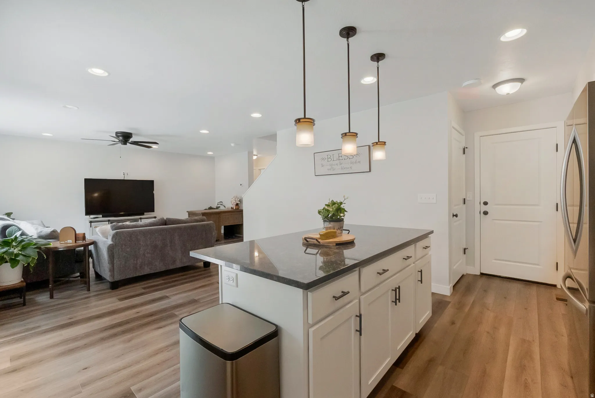Kitchen island featuring a dark countertop and white cabinetry with dark hardware
