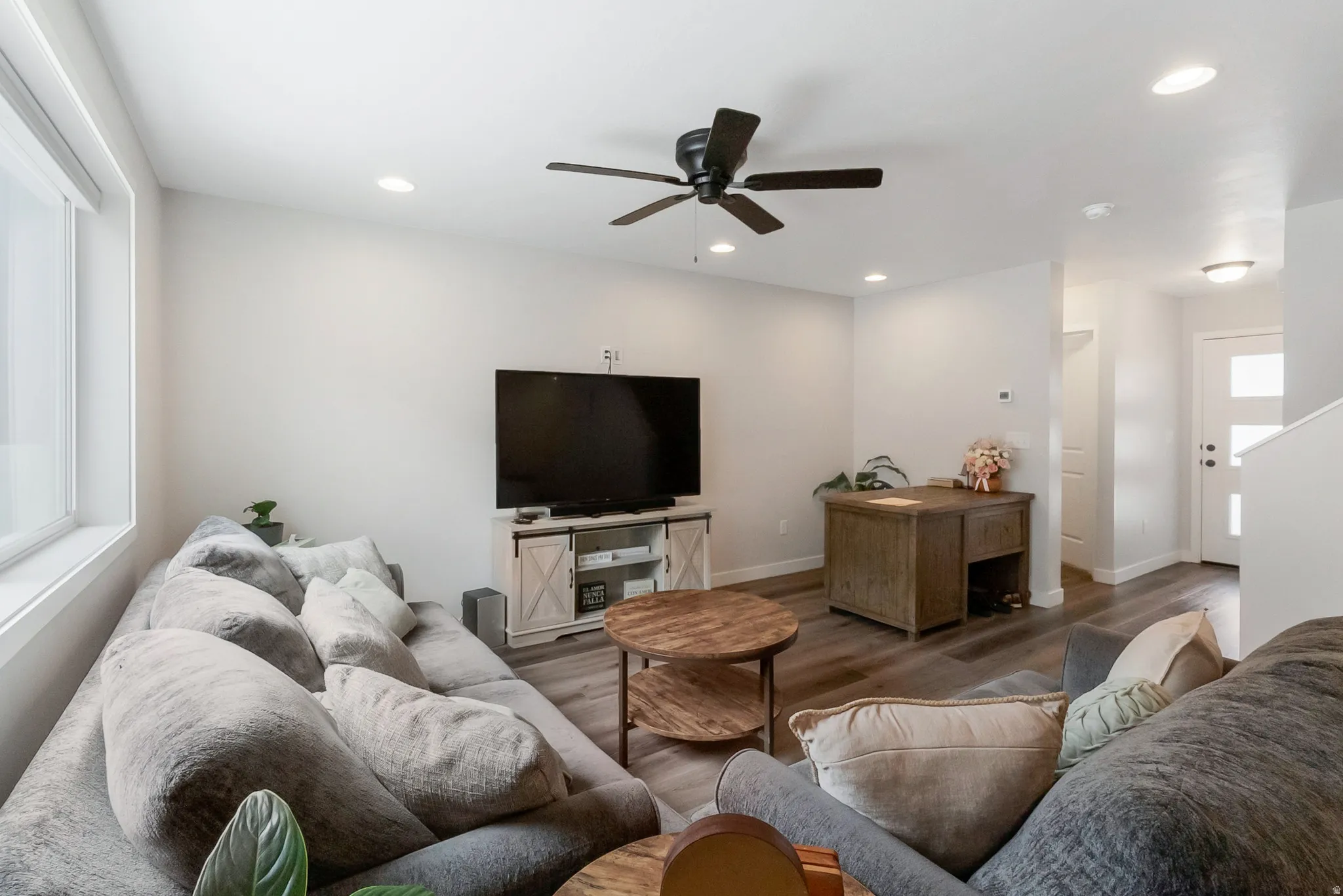 Living area featuring wood-finish flooring, recessed lighting, and a ceiling fan