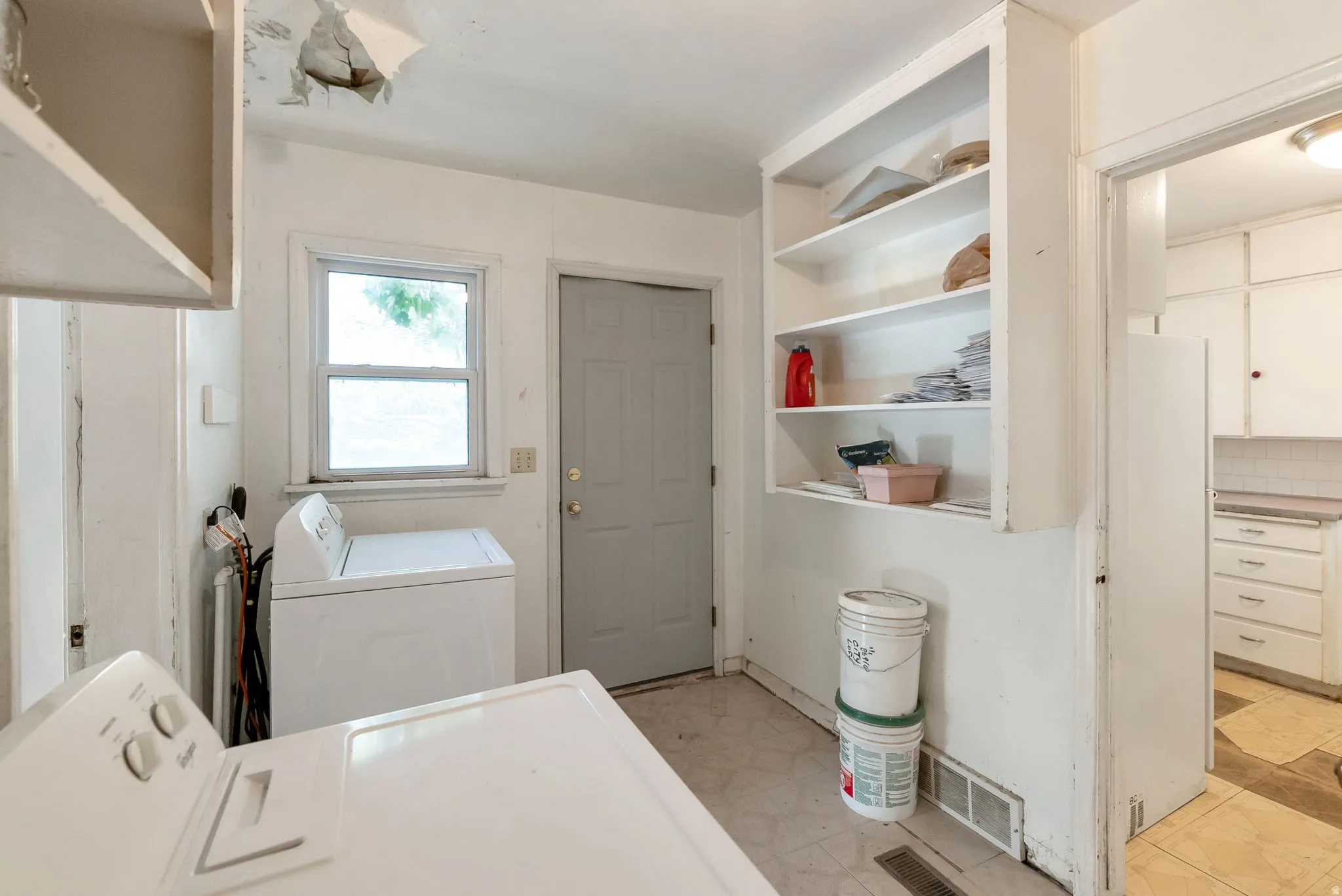 Utility space featuring built-in shelving, a window, and a door