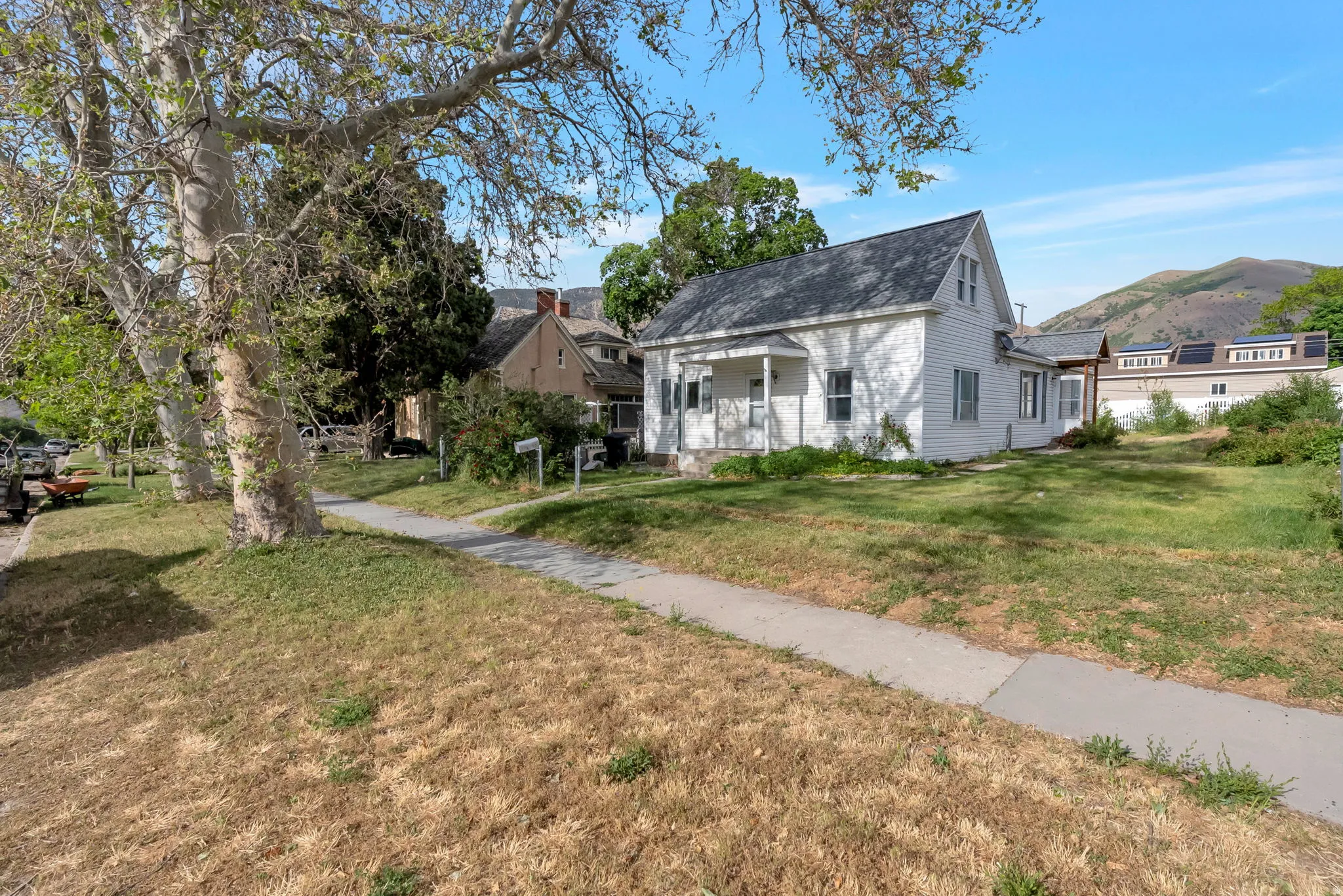Charming white siding residence featuring a gabled roofline and covered front porch
