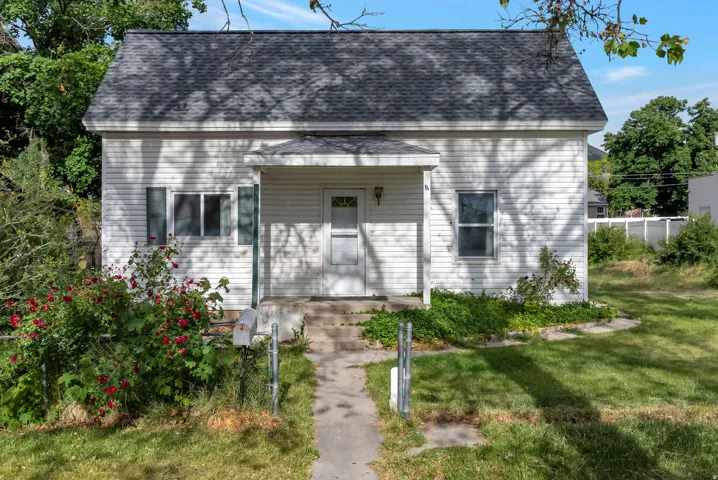 White siding exterior with a dark shingle roof, featuring a covered front entry with steps