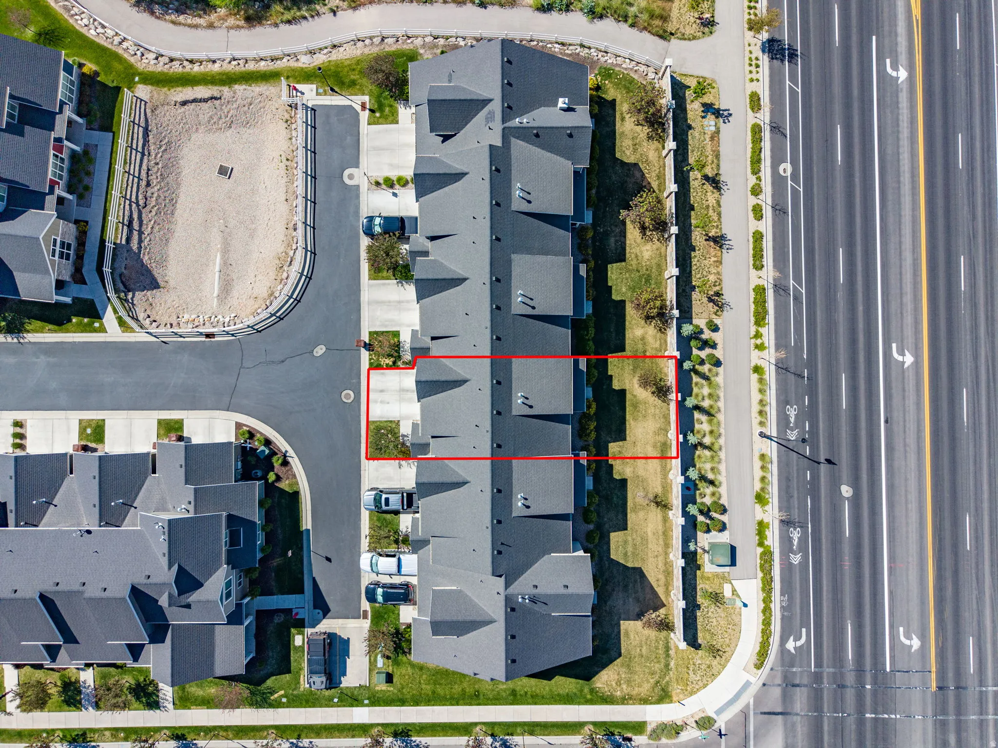 Aerial perspective highlighting the property with its dark gray roofline and individual parking spaces