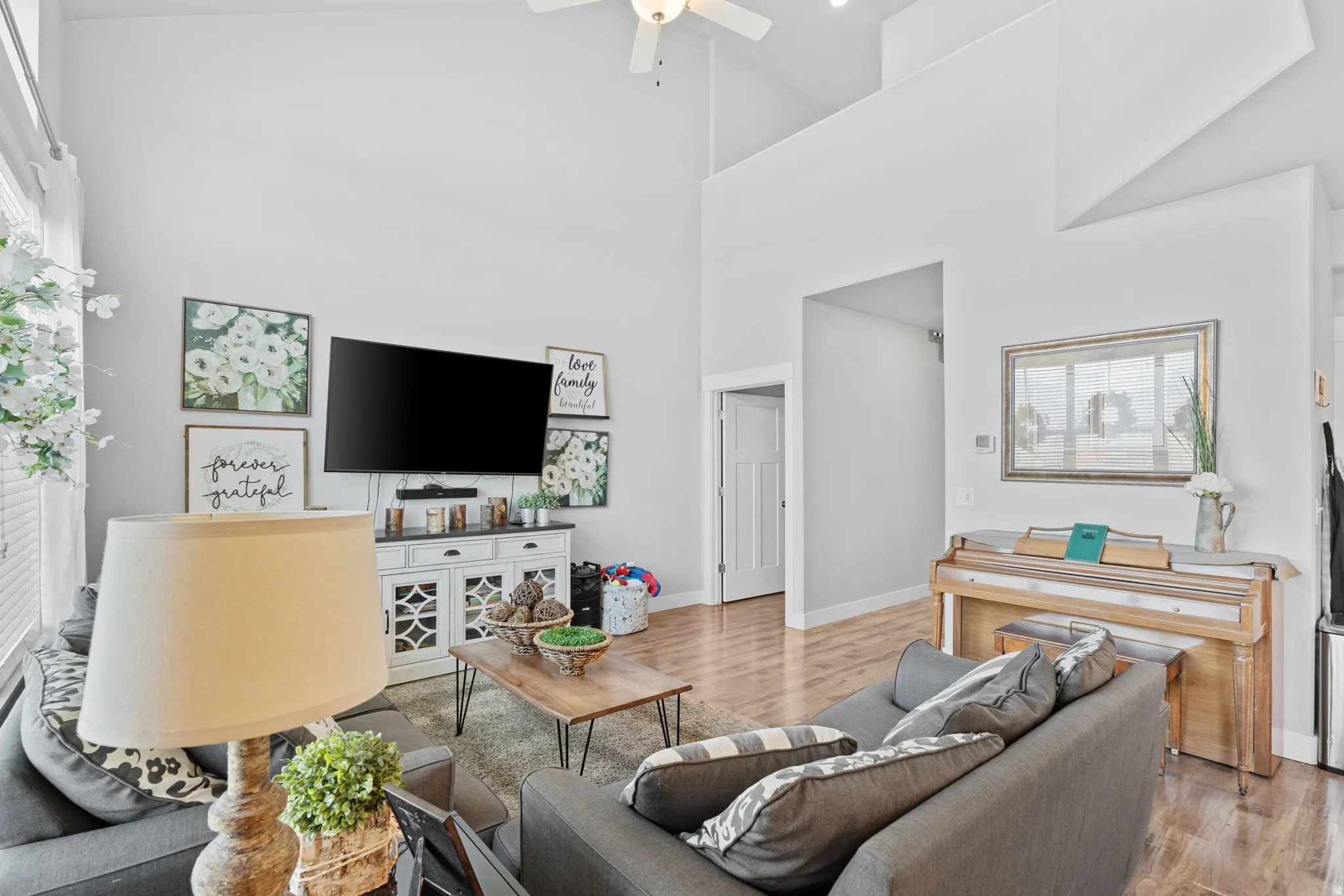Living area featuring a soaring vaulted ceiling, recessed lighting, and wood-finish flooring