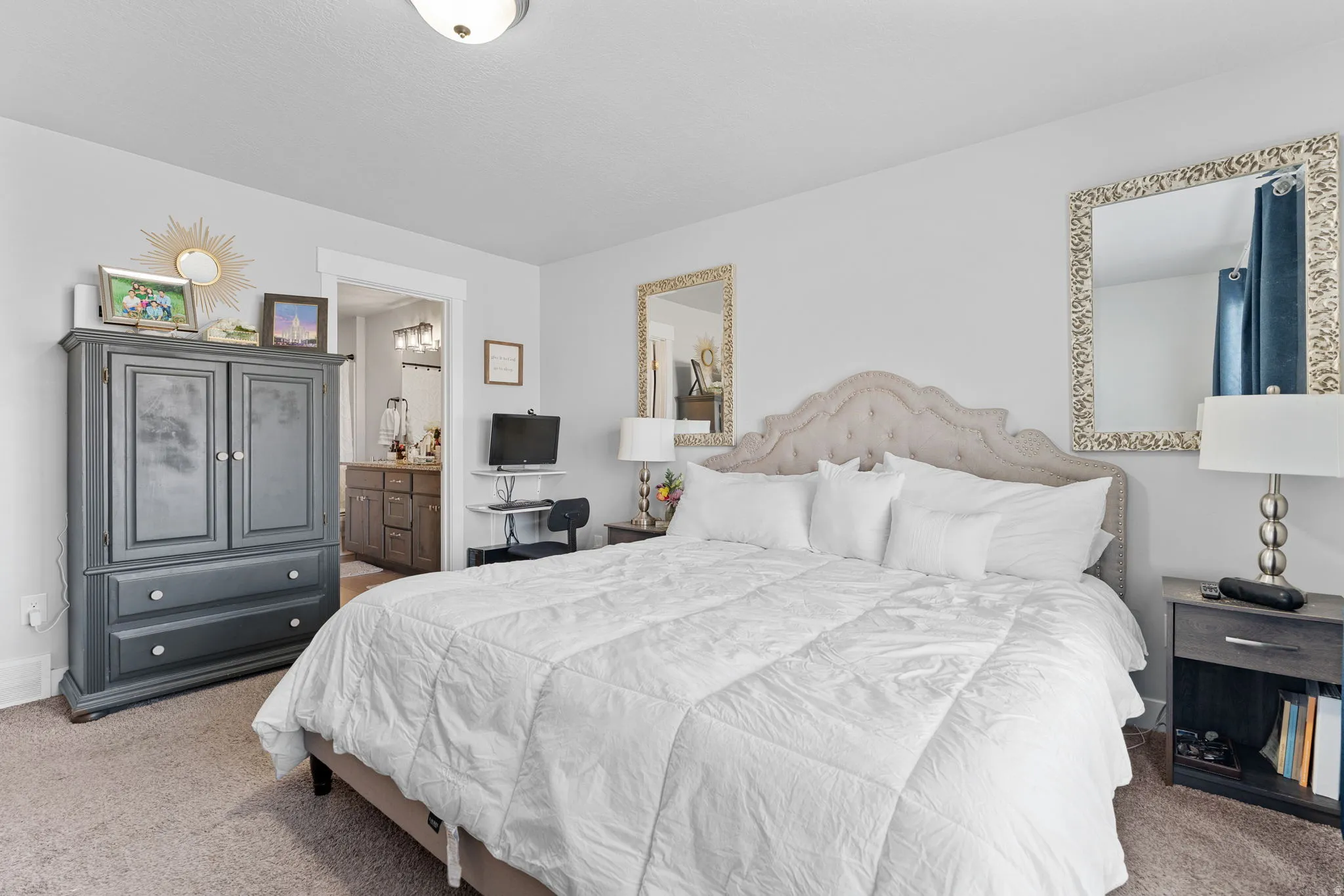 Carpeted room with a tufted headboard, white trim, and a ceiling-mounted light fixture
