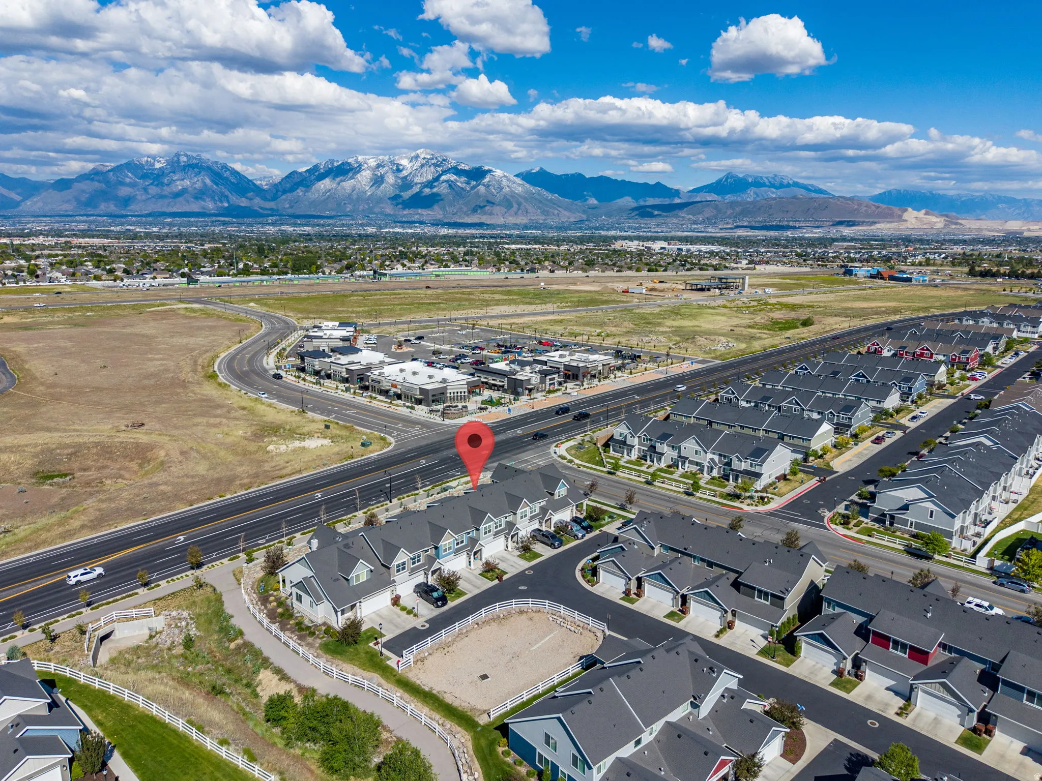 Aerial perspective showcasing a community of townhomes and houses with gray roofs