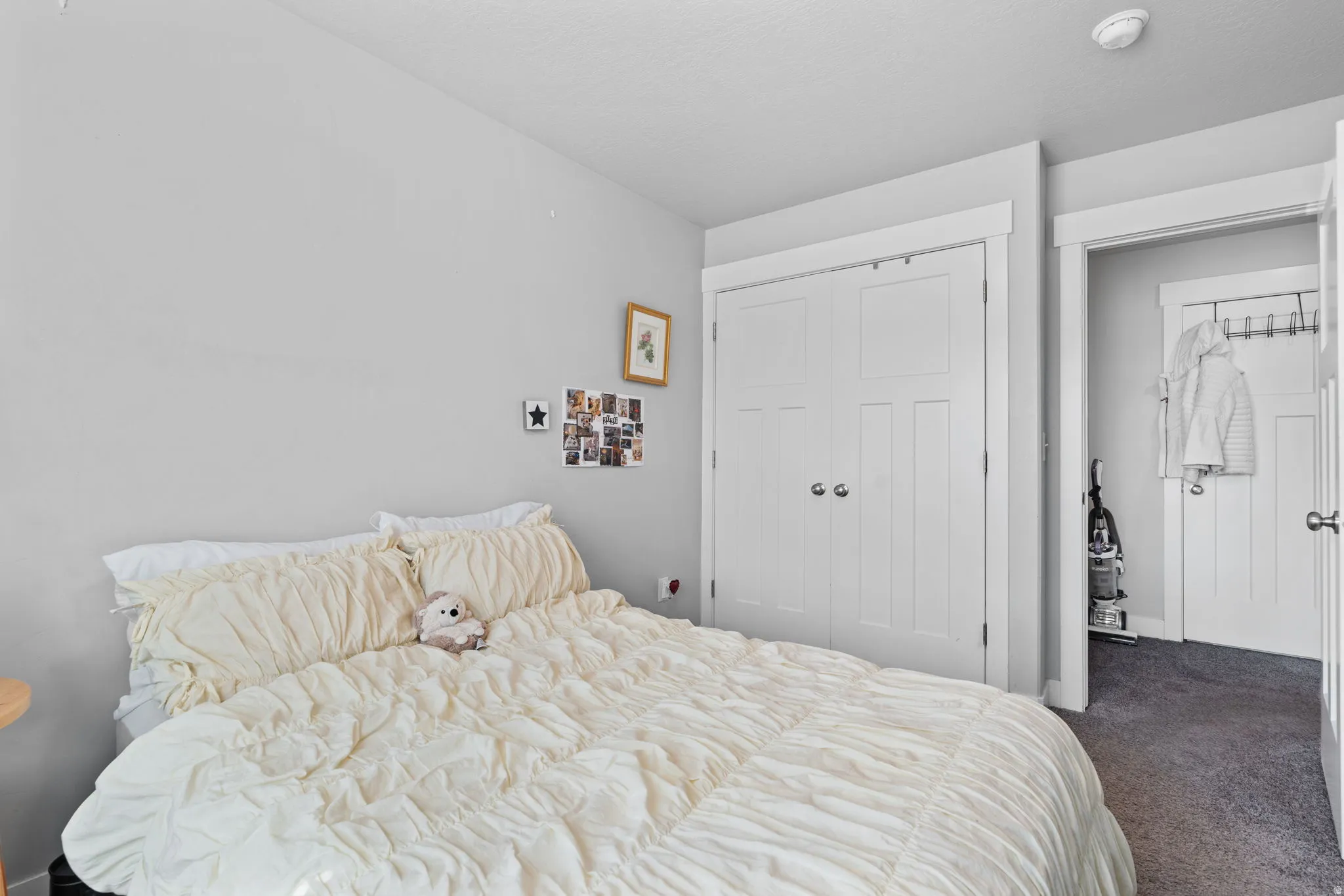 Bedroom featuring light gray walls, white trim, and a textured carpeted floor