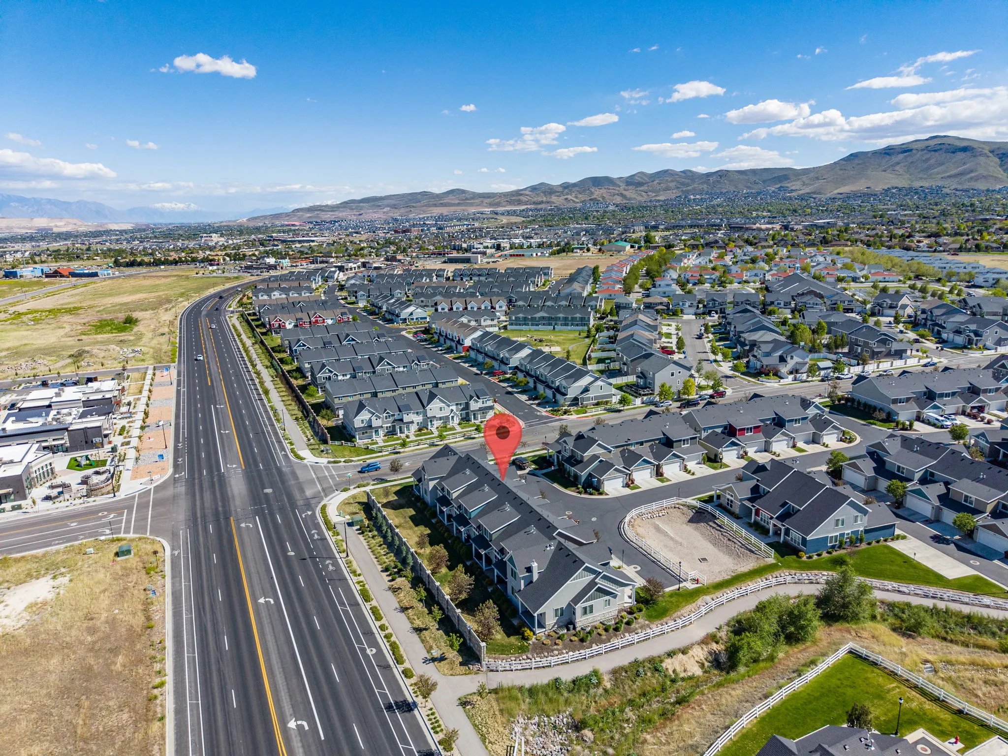 Aerial perspective showcasing a community of residential properties with dark-toned roofing and light-colored siding
