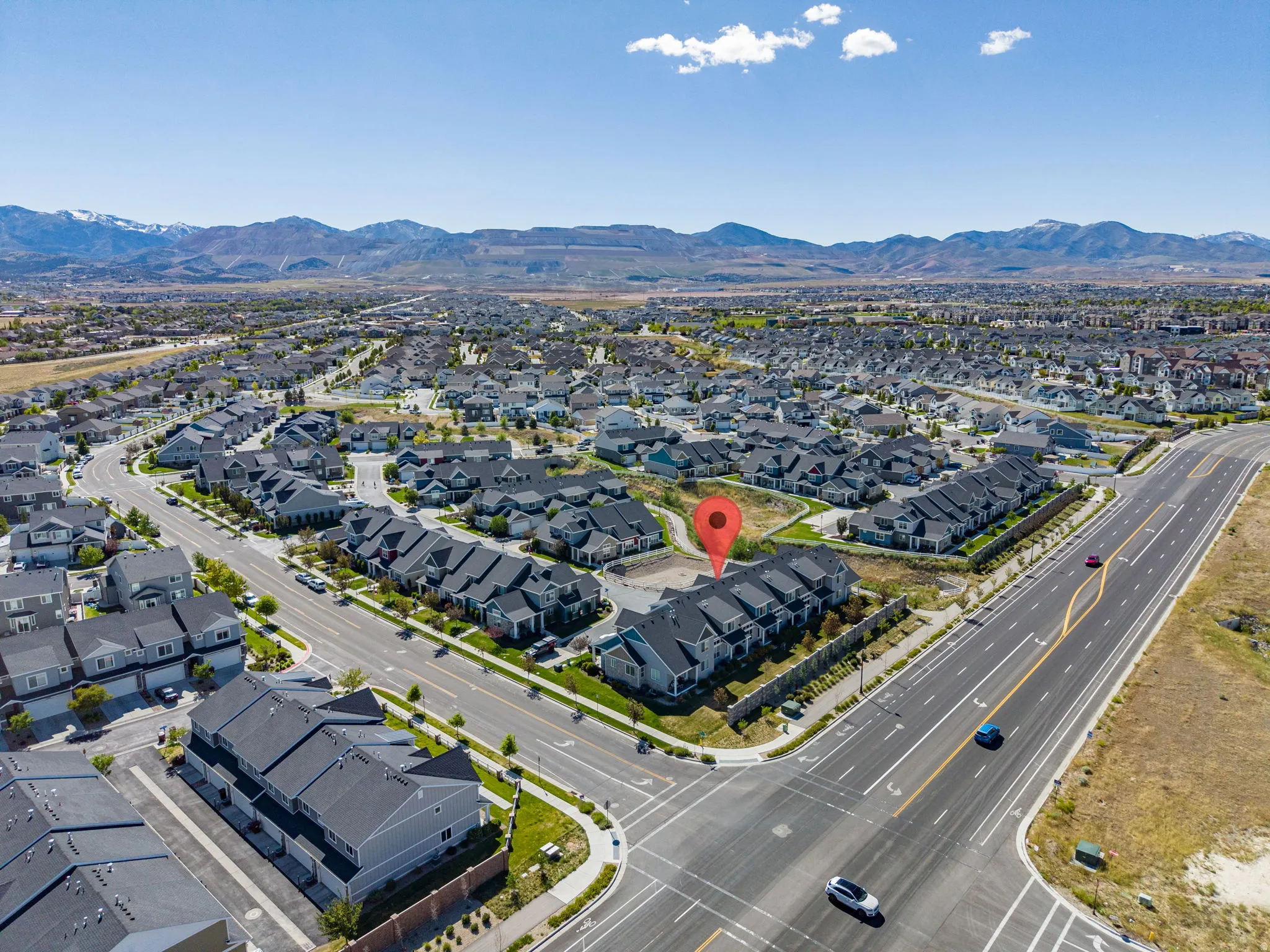 Expansive aerial perspective showcasing a residential development with mountain backdrops