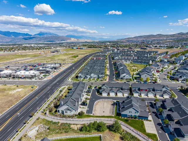 Expansive aerial capture showcasing a residential community with contemporary architecture and a mountainous backdrop