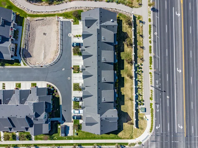 Aerial view of residential structures featuring dark gray shingled roofs