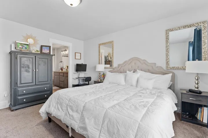 Carpeted room with a tufted headboard, white trim, and a ceiling-mounted light fixture