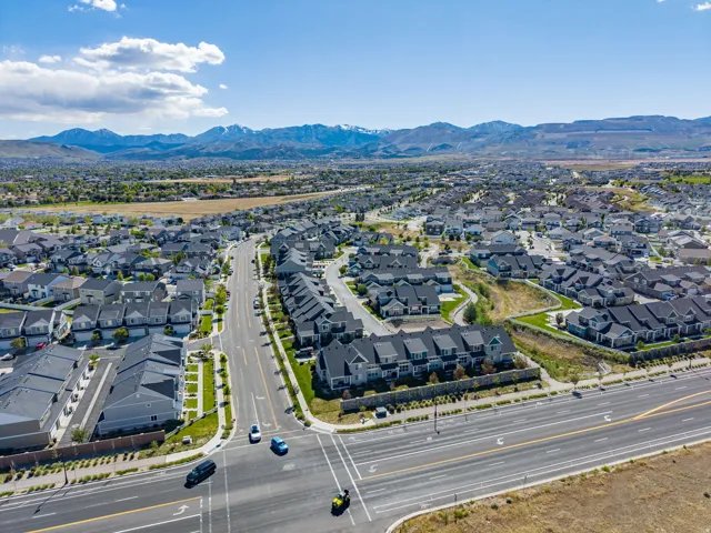 Expansive aerial perspective showcasing a residential neighborhood with distant mountain ranges