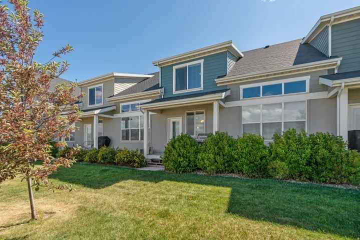 Rear exterior featuring multiple windows, a sliding glass door, and a covered patio area