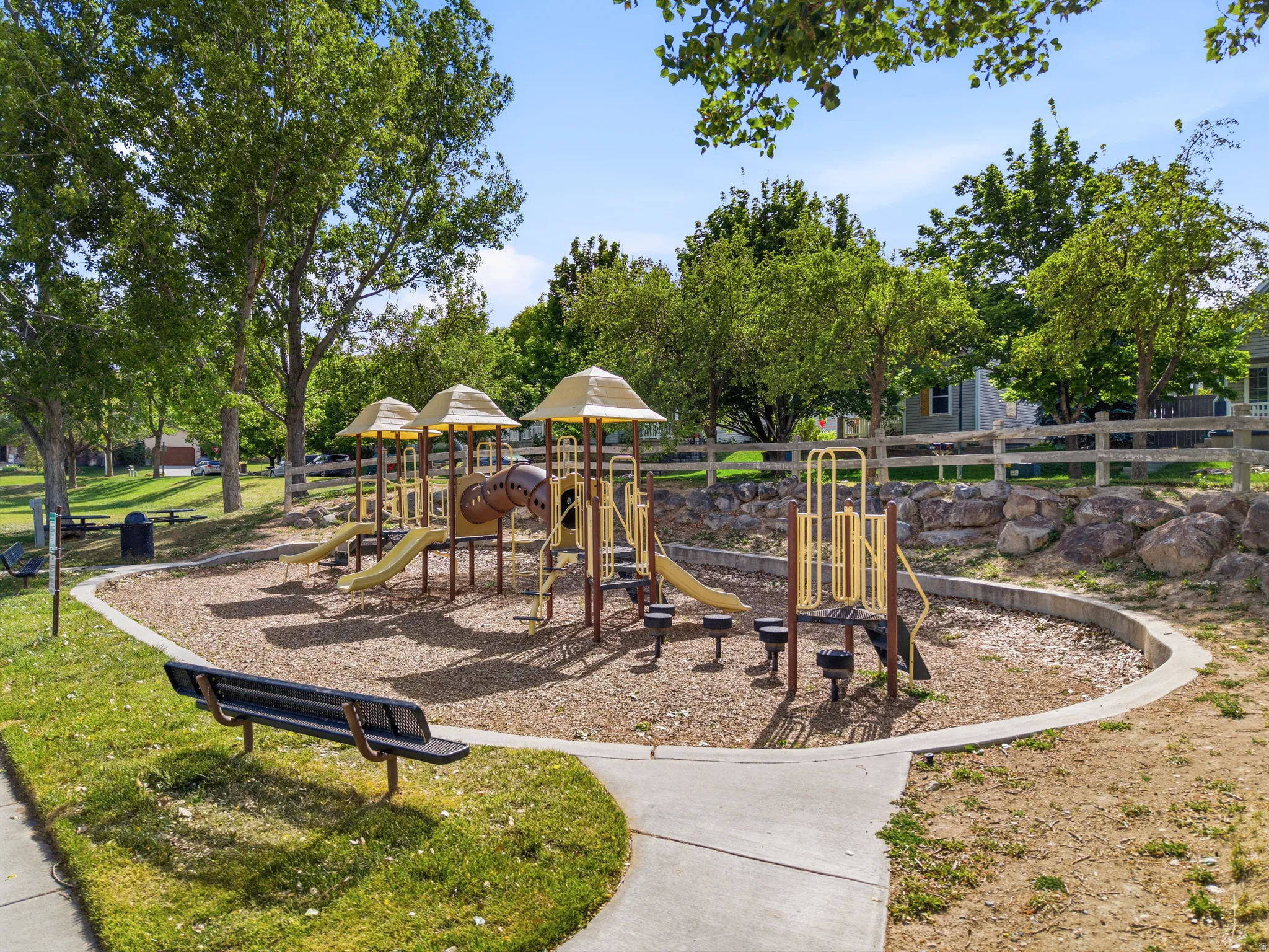Across the street community playground featuring multiple slides and climbing structures on a wood chip surface