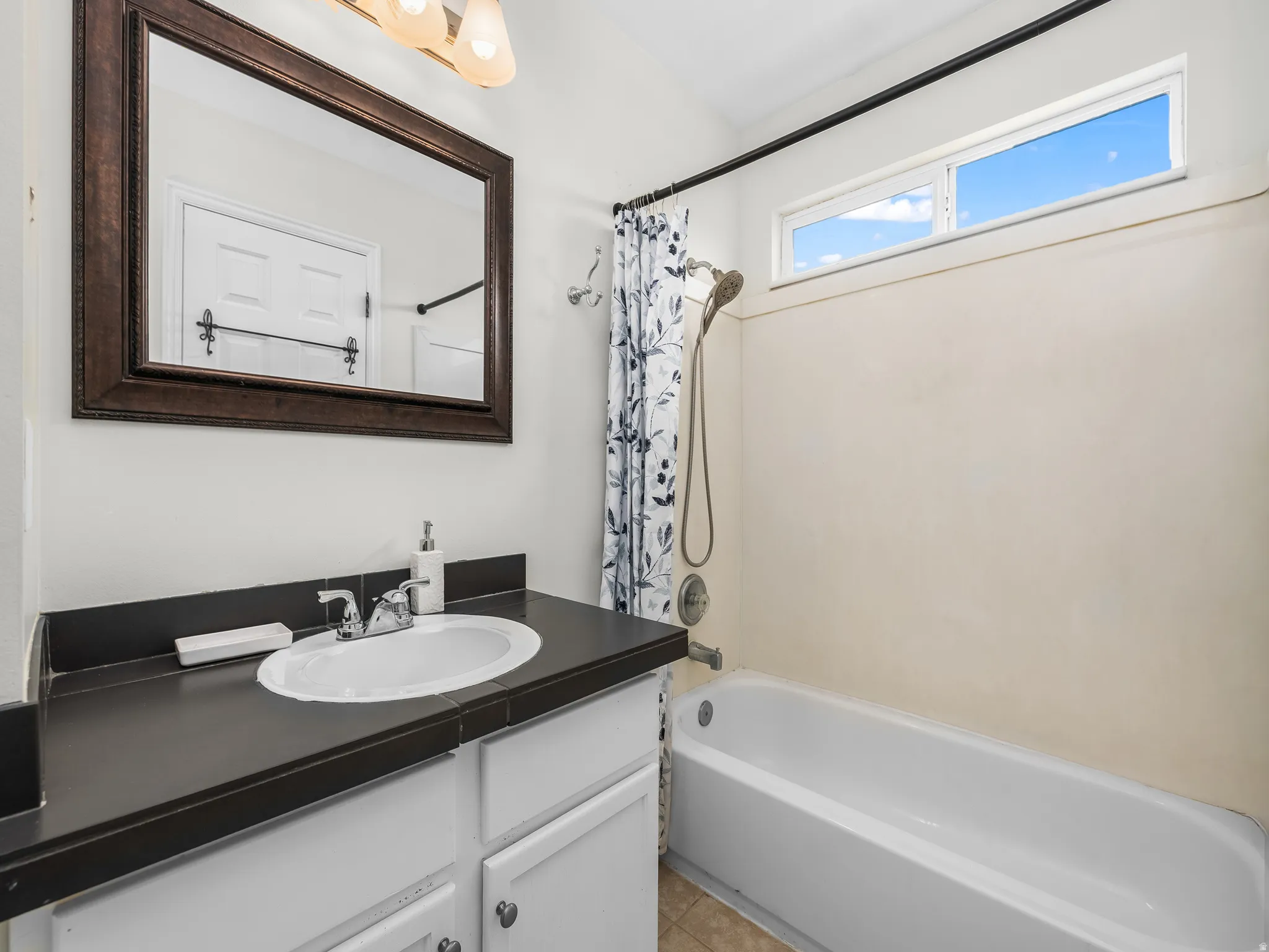 Master Bathroom featuring a vanity with an oval sink, dark countertop, and white cabinetry