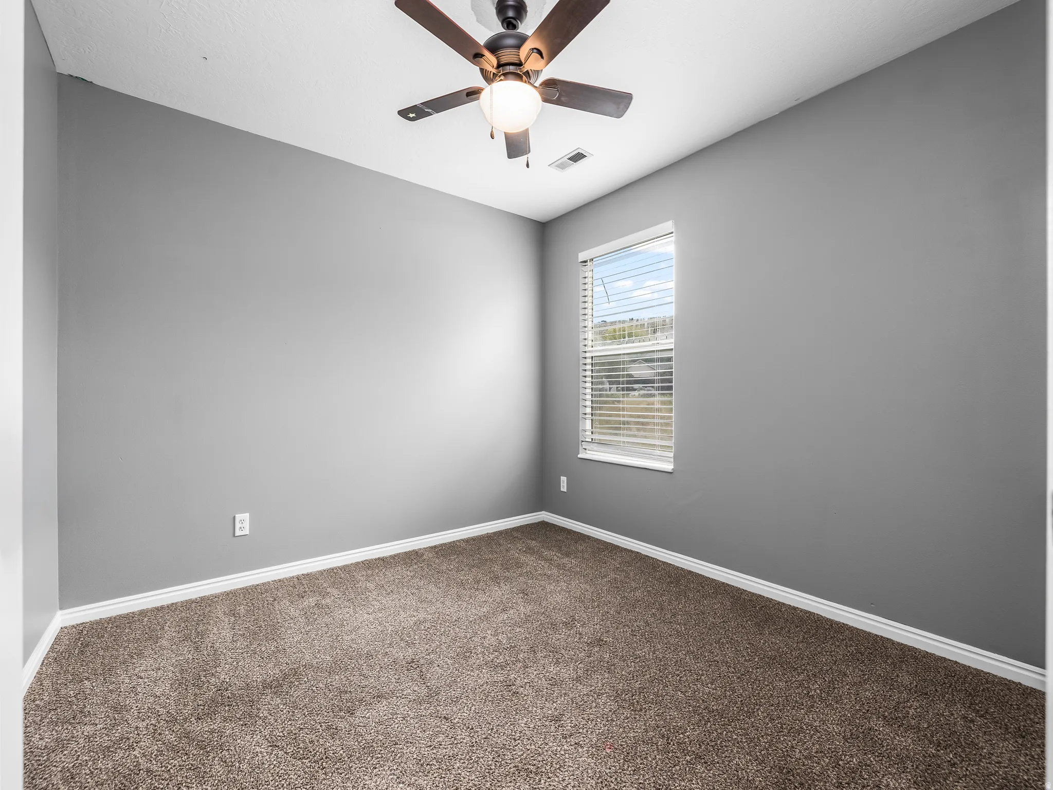 Bed 3 Neutral gray walls complement brown carpet flooring