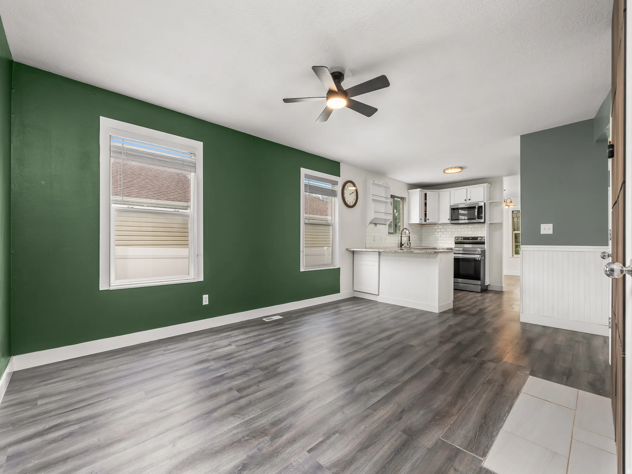Open-concept living area featuring wood-finish flooring and a ceiling fan