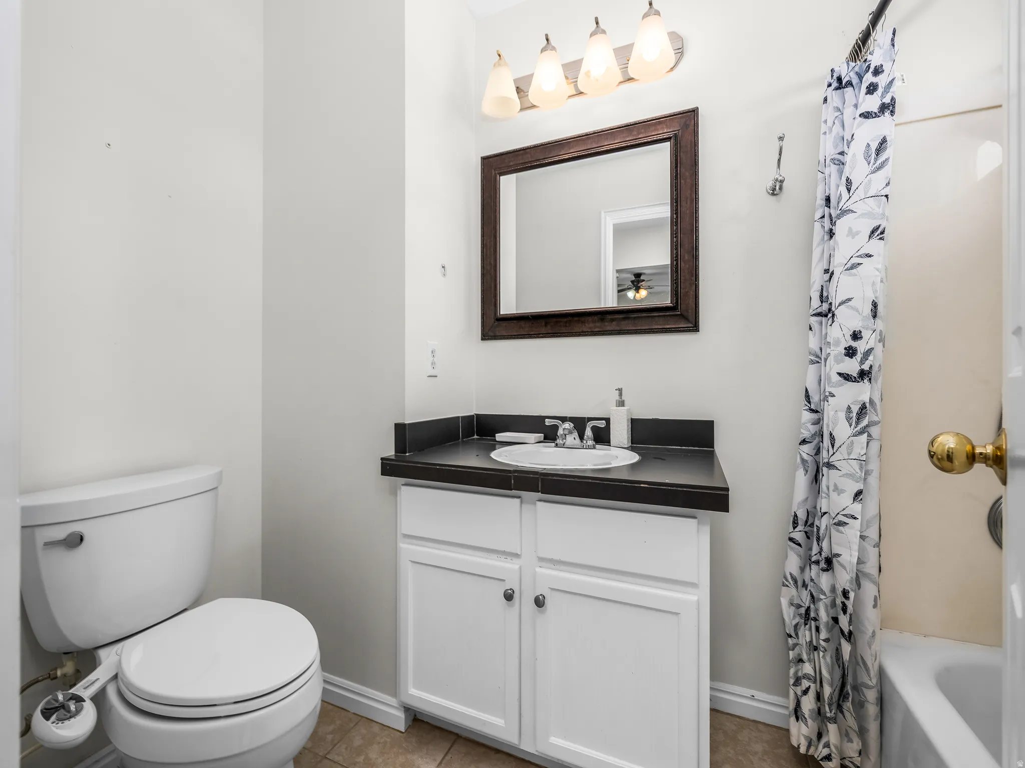 Master Bathroom featuring a white vanity with a dark countertop, an undermount sink, and a framed mirror