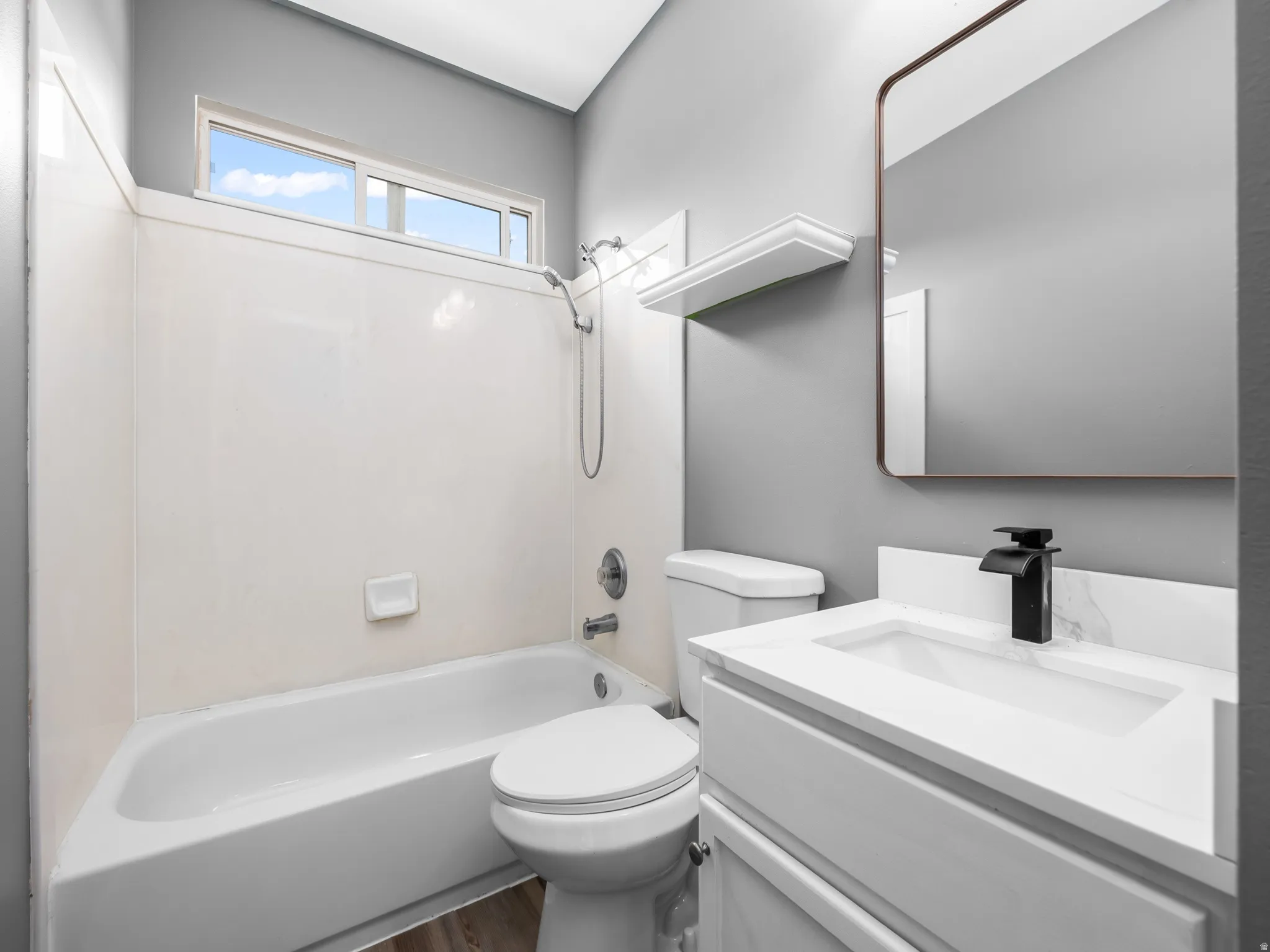 Modern bathroom featuring a white vanity with an integrated sink and matte black faucet