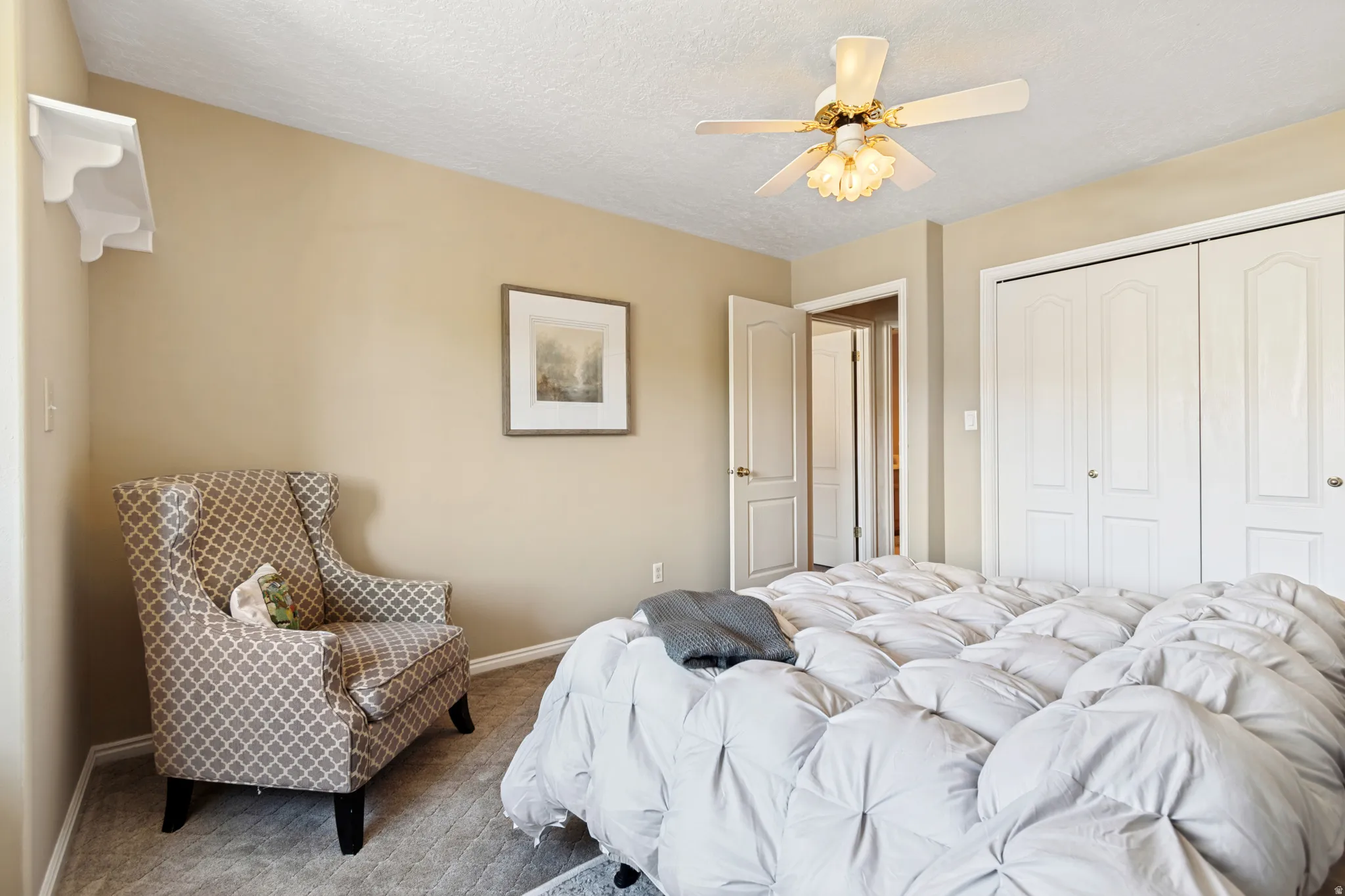 Carpeted bedroom featuring neutral-toned walls and a textured ceiling