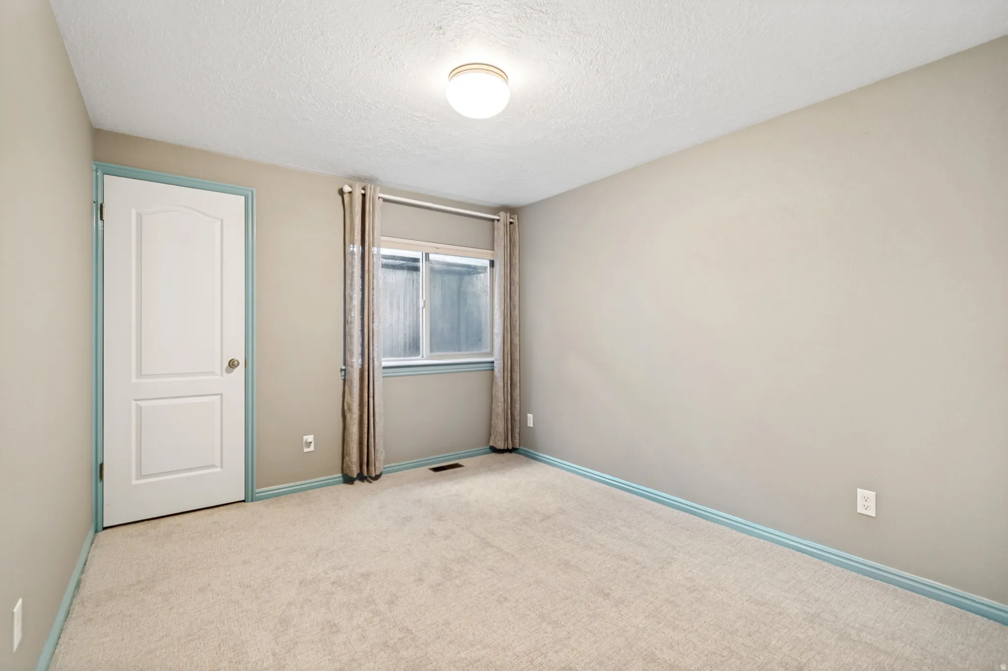 Spacious room featuring neutral carpeting and light gray wall paint