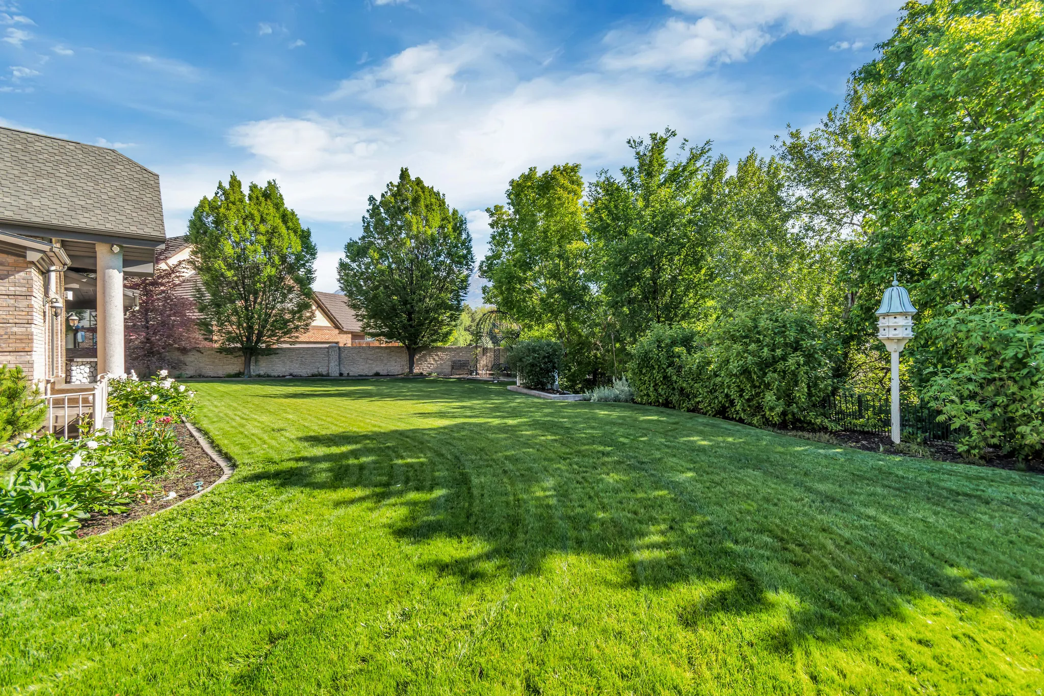 Expansive lawn featuring mature trees and established landscaping
