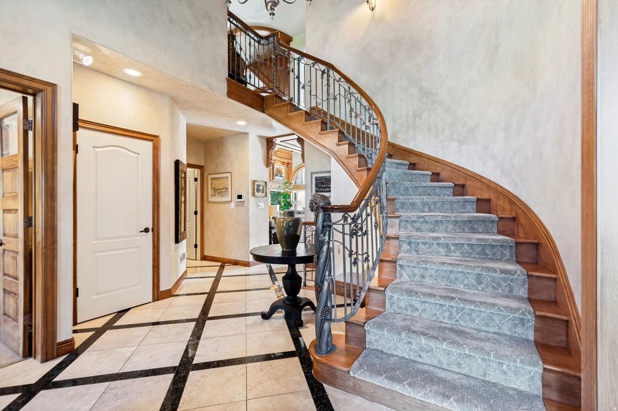 Curved staircase featuring wood treads and a wrought iron banister