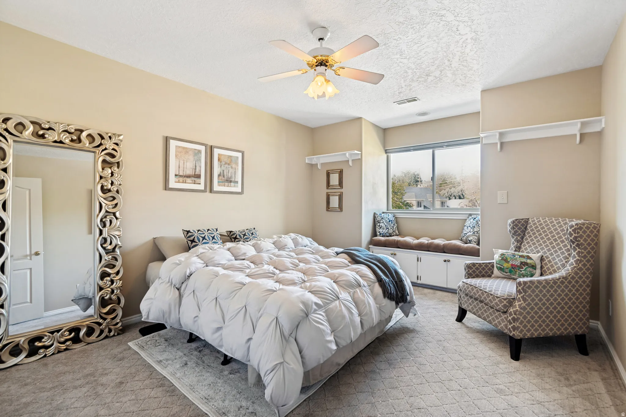 Bedroom with neutral wall paint and patterned carpeting