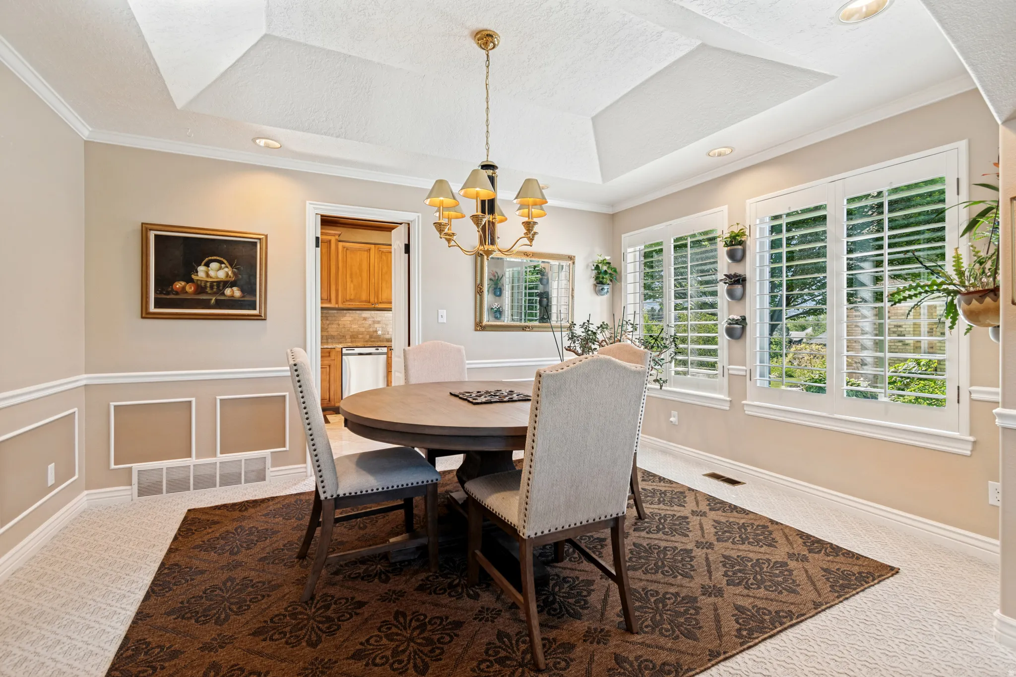 Tray ceiling with recessed lighting and a central chandelier