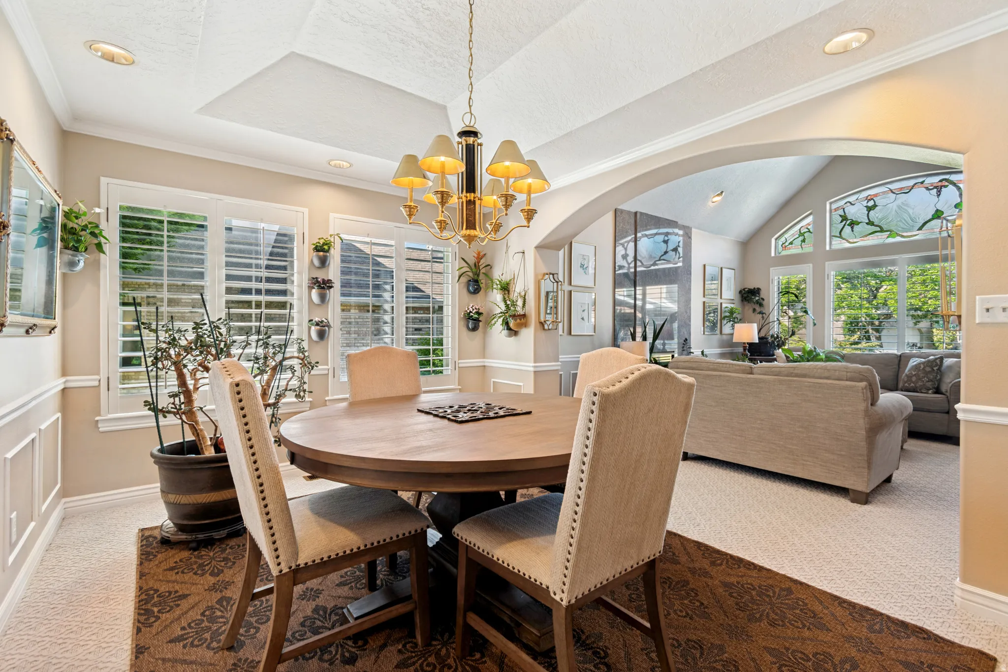 Dining area featuring a tray ceiling with recessed lighting and a chandelier