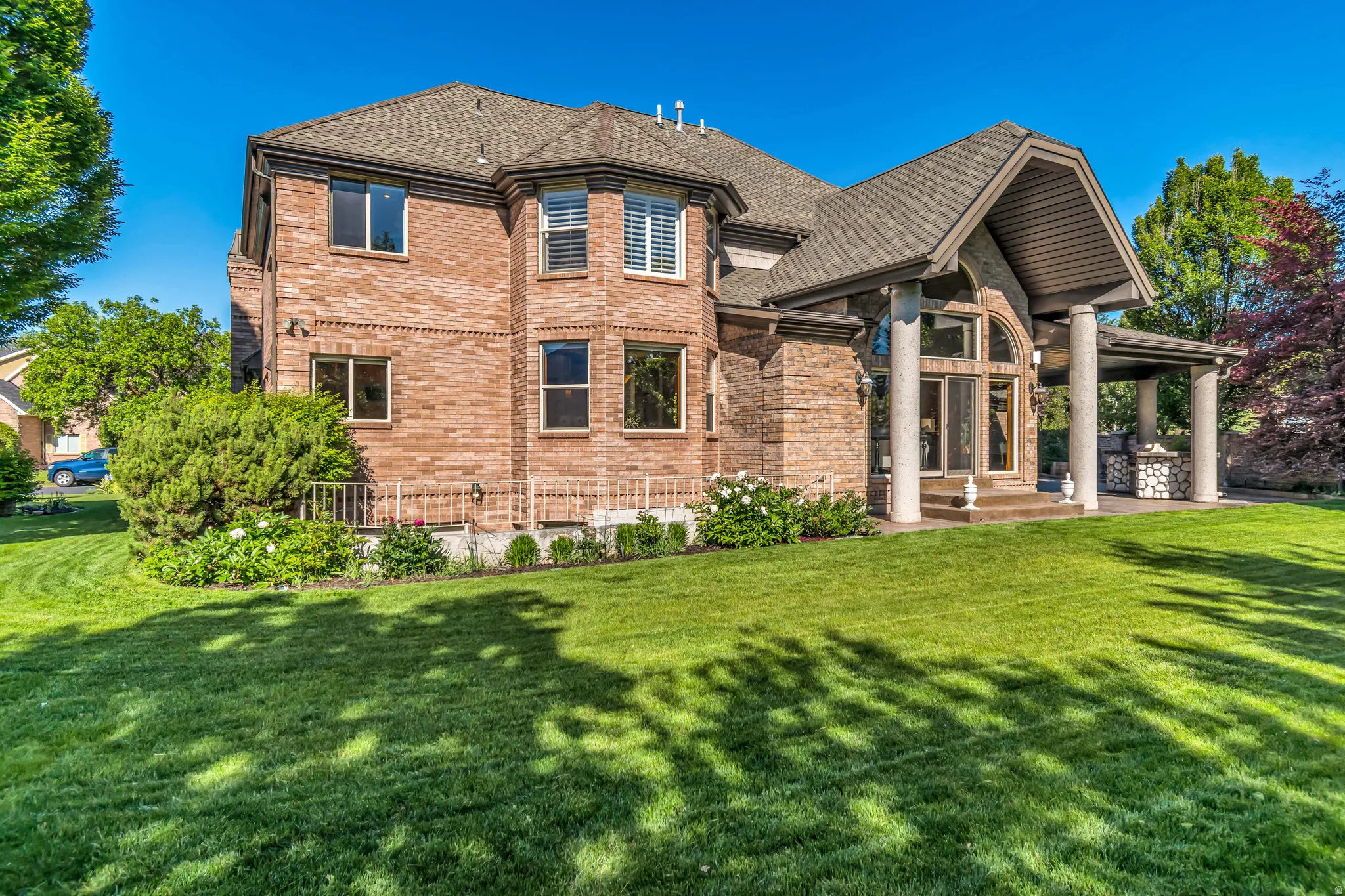 Brick exterior featuring a covered patio with columns and an arched entryway