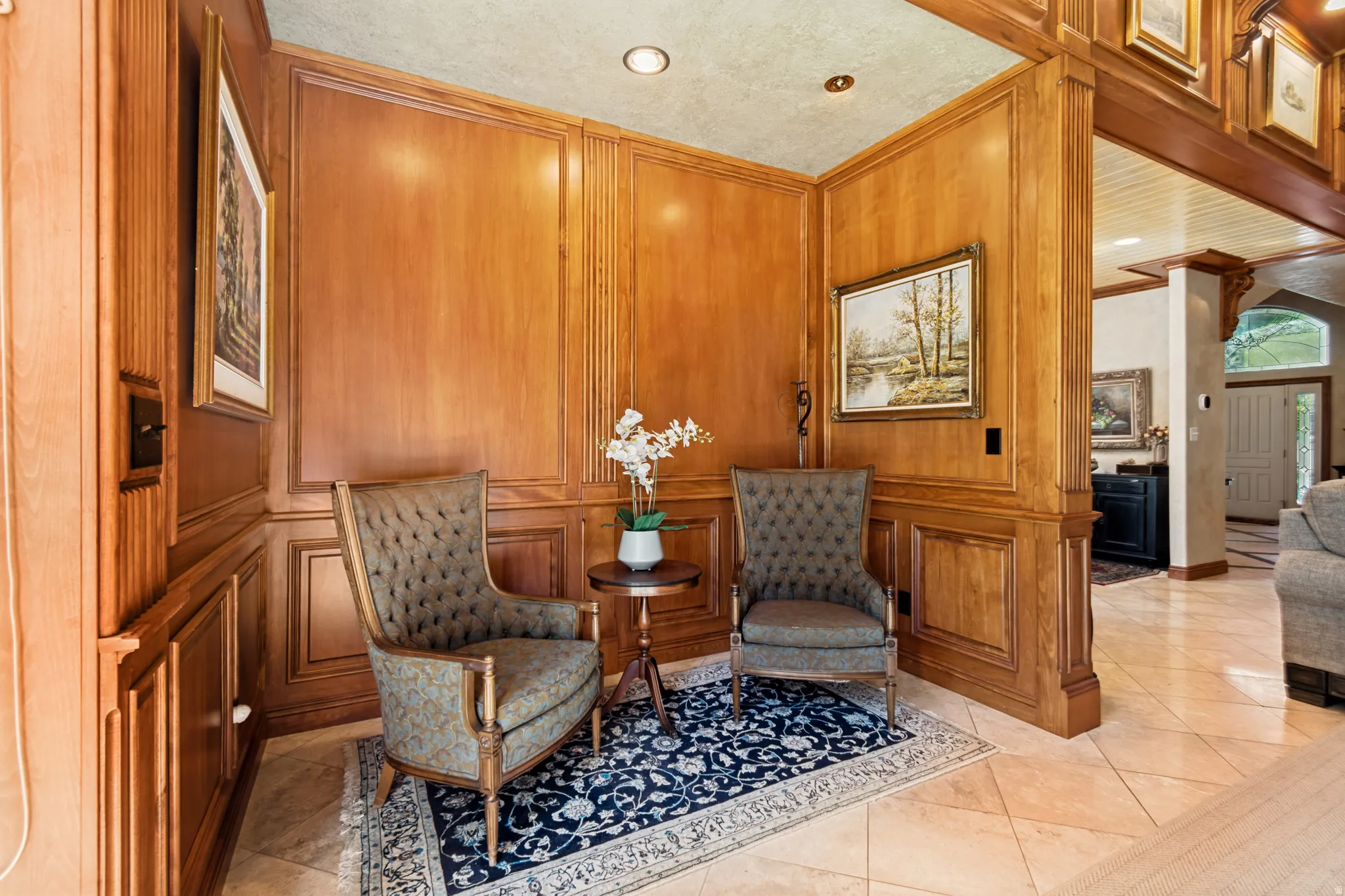 Custom wood paneling with wainscoting details, recessed lighting, and tile flooring