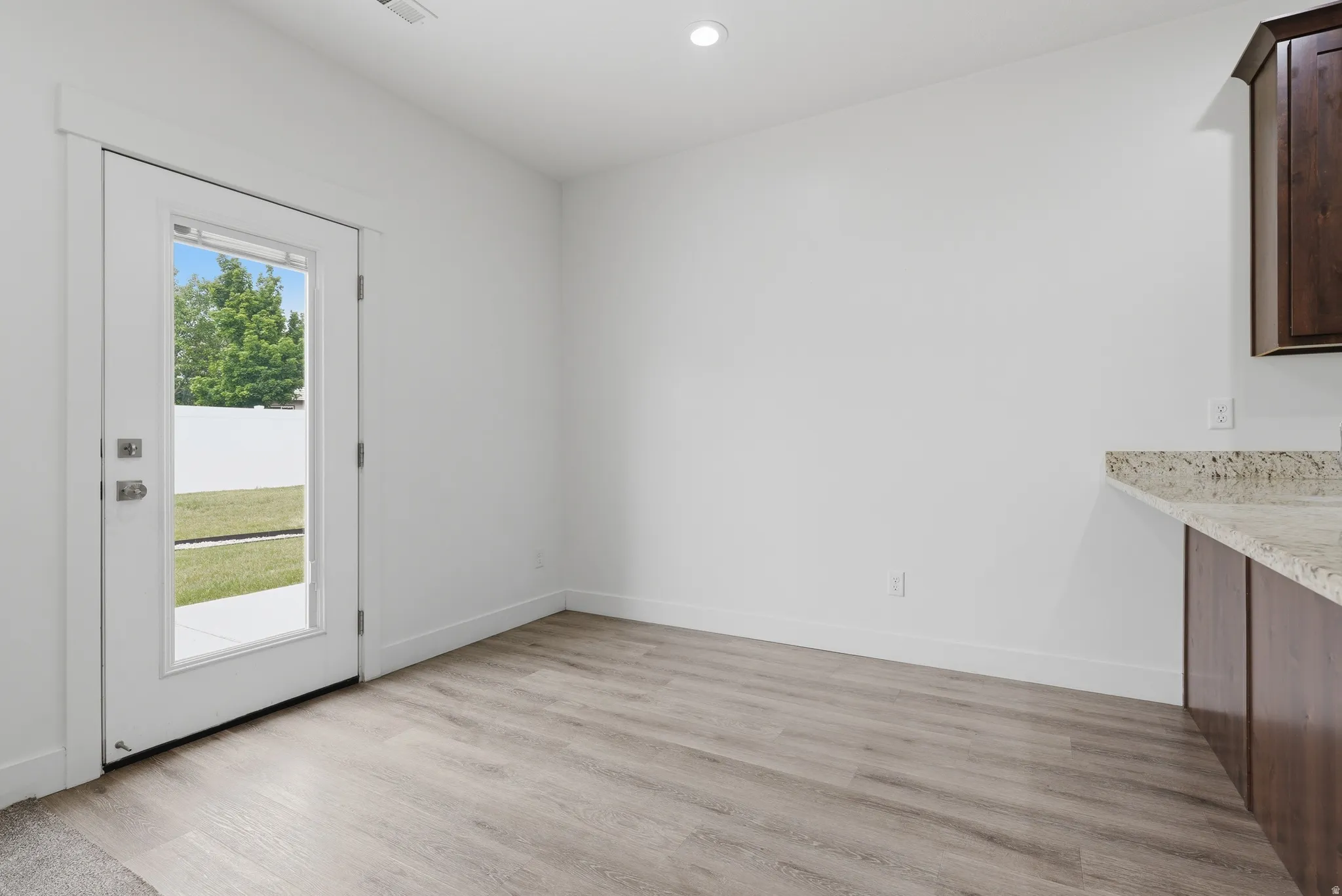 Light wood-finish flooring with a white trim baseboard