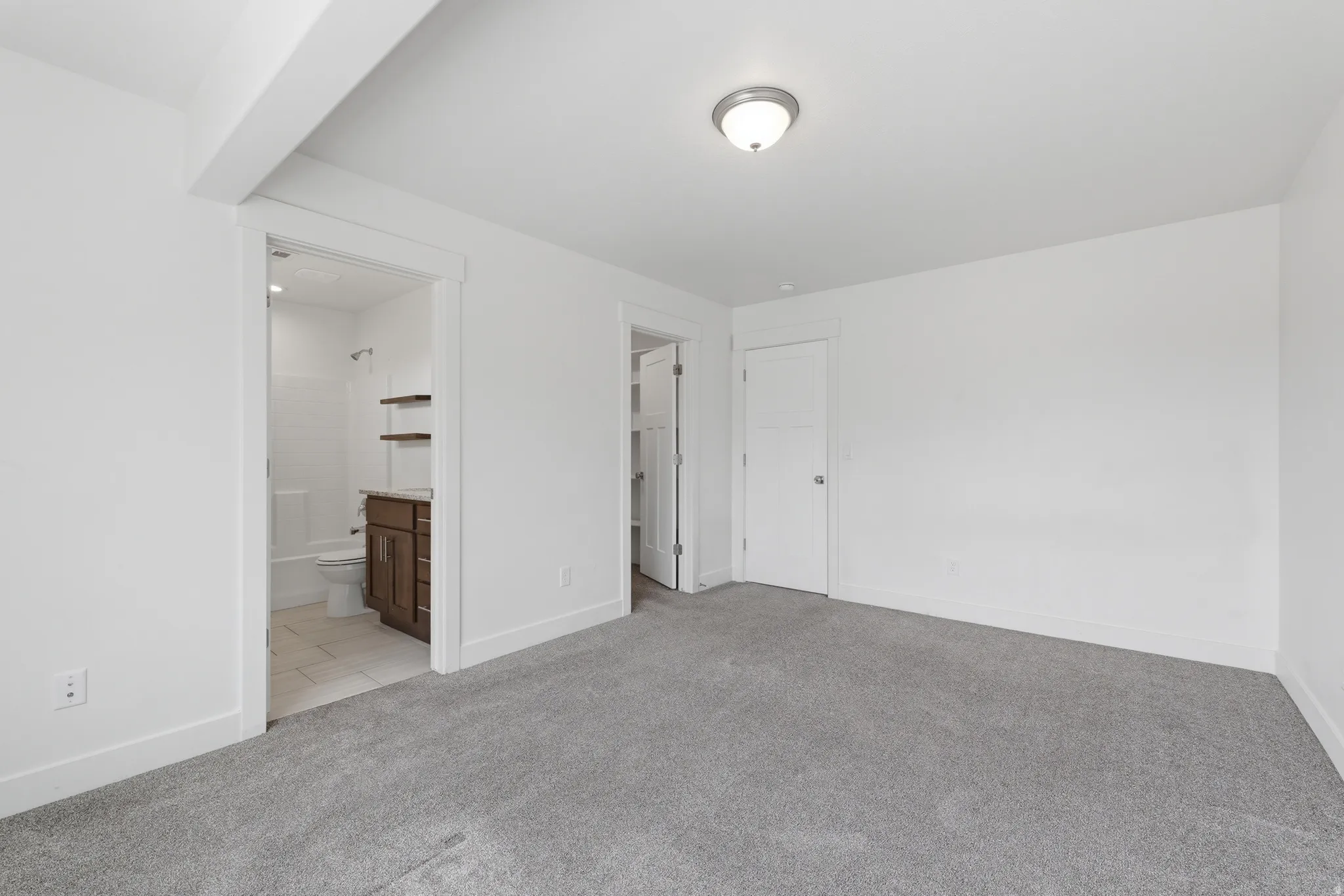 Spacious room with light gray carpet and white walls