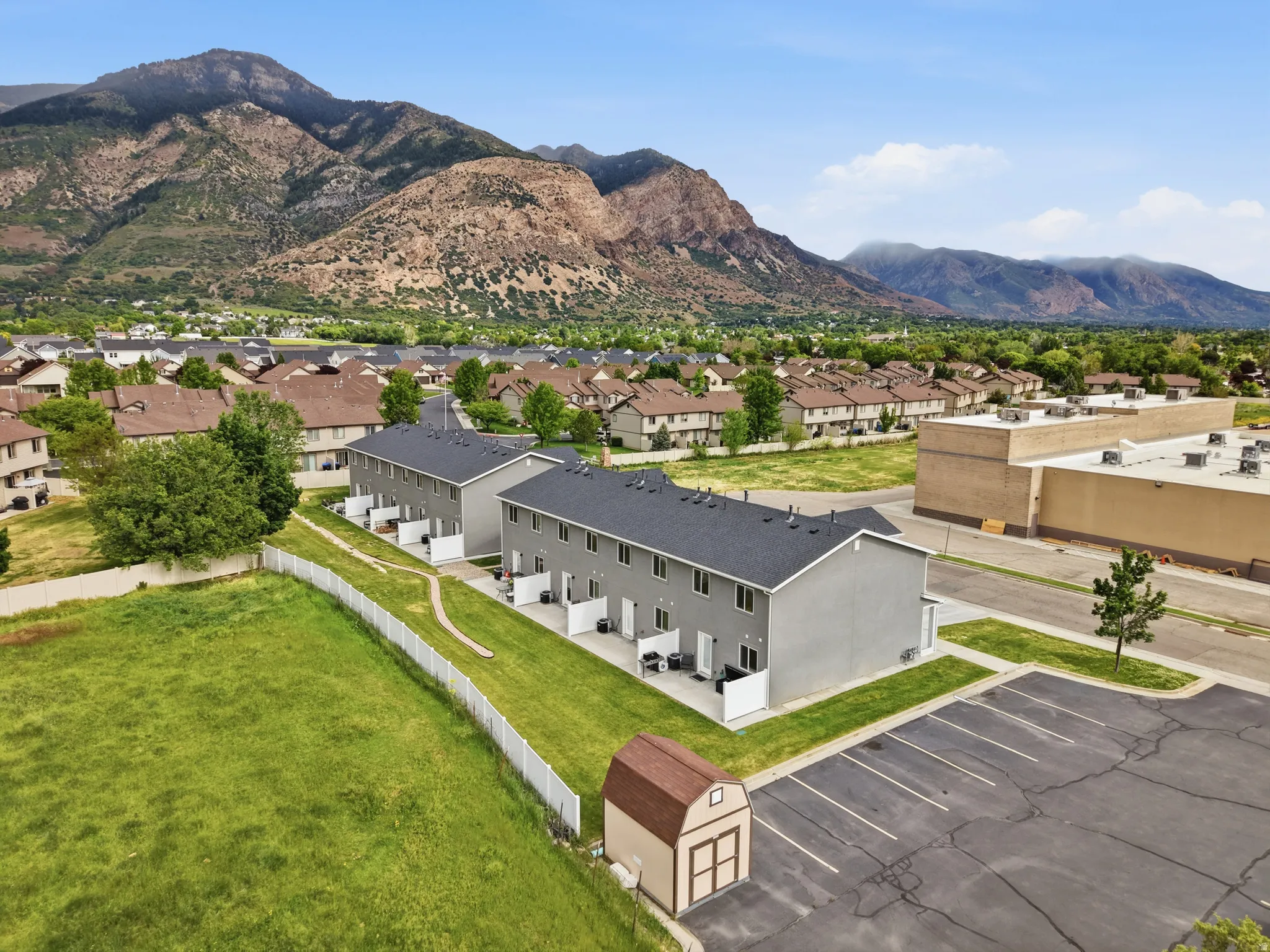Modern townhome exteriors featuring light gray siding and dark shingle roofs
