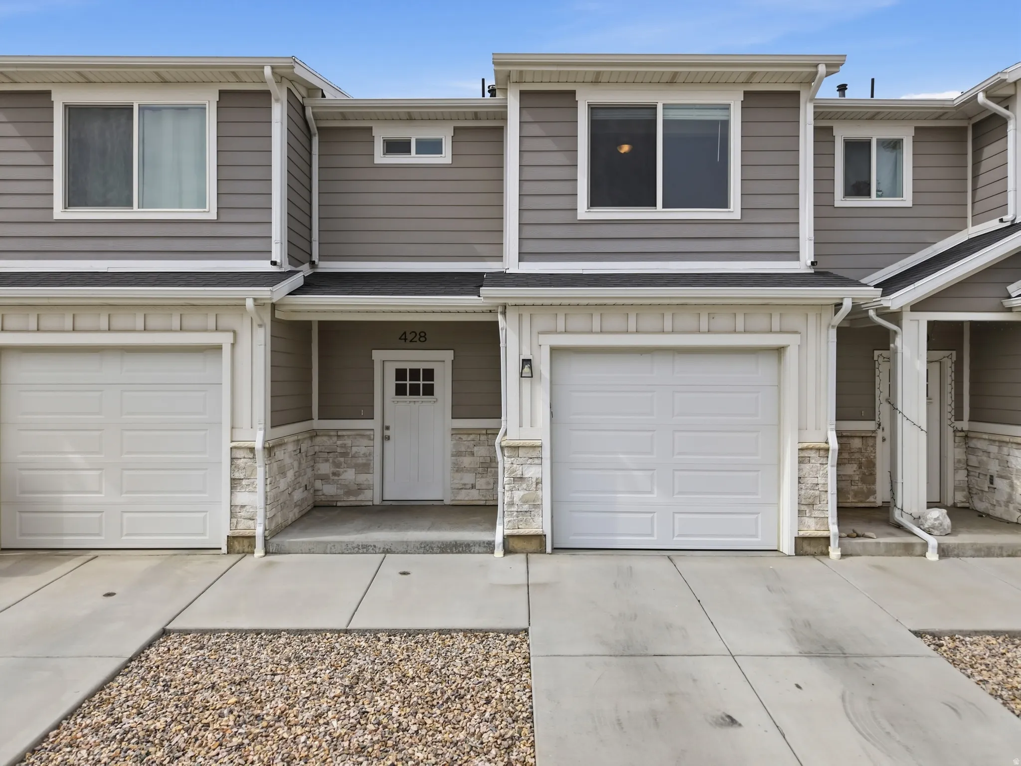 Contemporary townhome exterior featuring horizontal siding and stone veneer accents