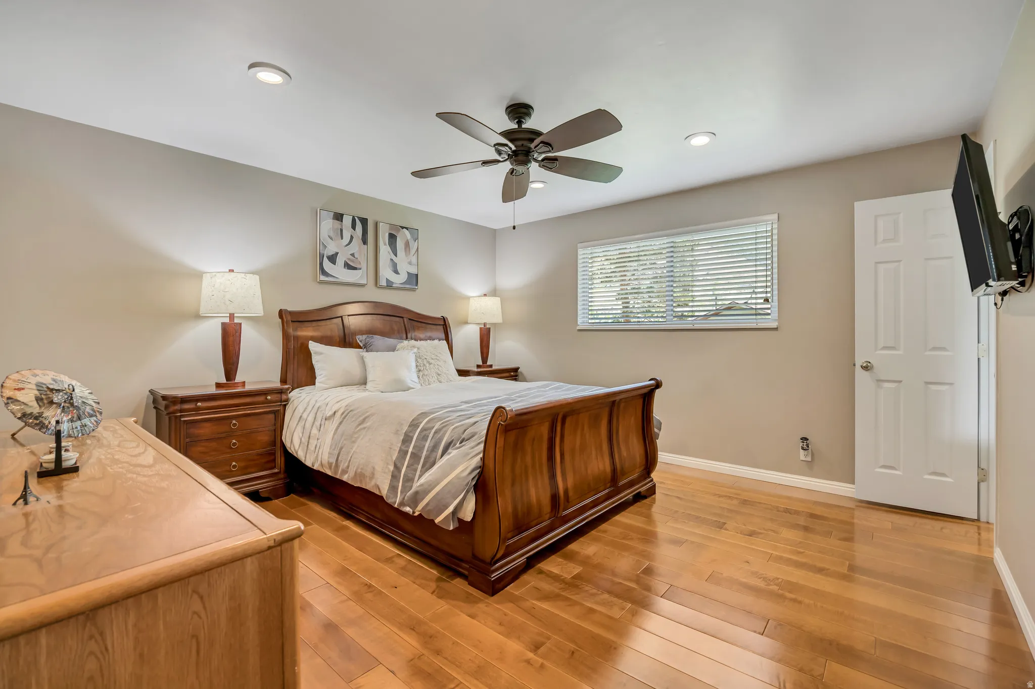Bedroom featuring wood-finish flooring, a ceiling fan with integrated lighting, recessed overhead lighting, and a window with blinds