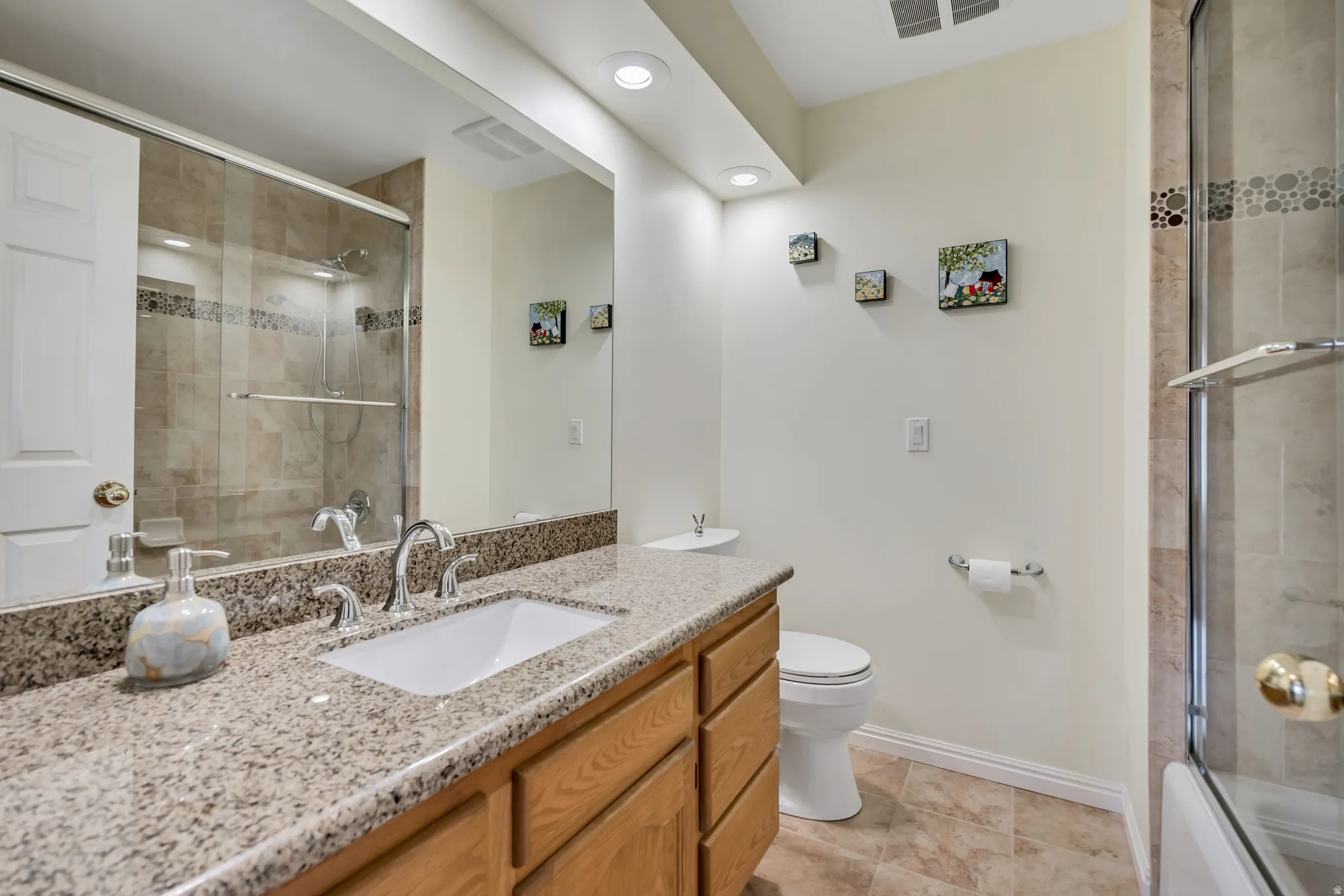 Bathroom featuring a light-toned vanity with an integrated sink and chrome fixtures