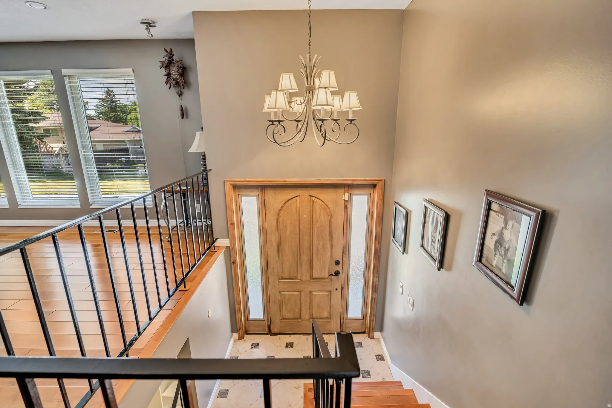 Two-story foyer featuring an arched wood-panel entry door with frosted glass sidelights