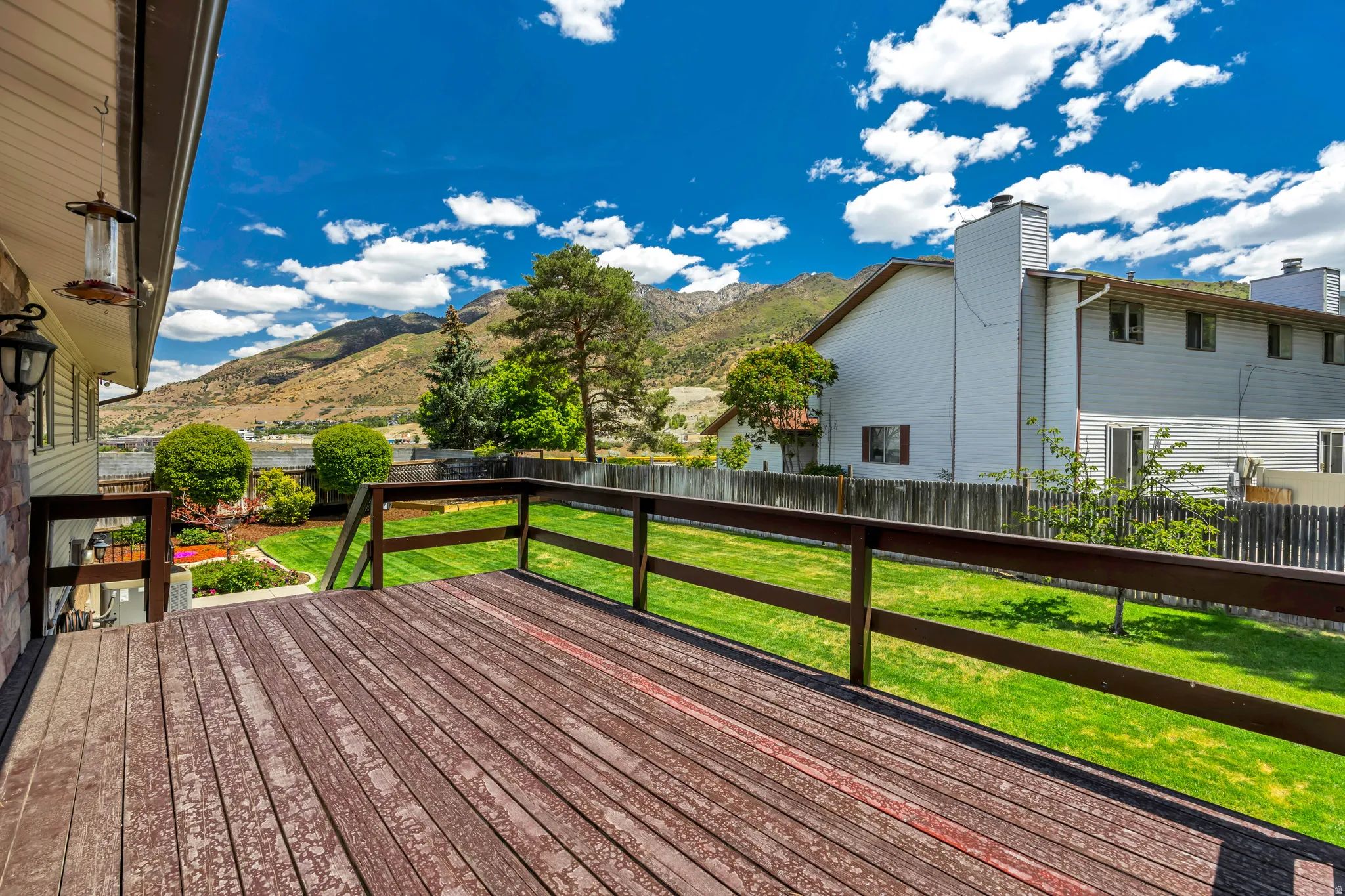 Expansive outdoor deck with wood flooring and dark wood railings