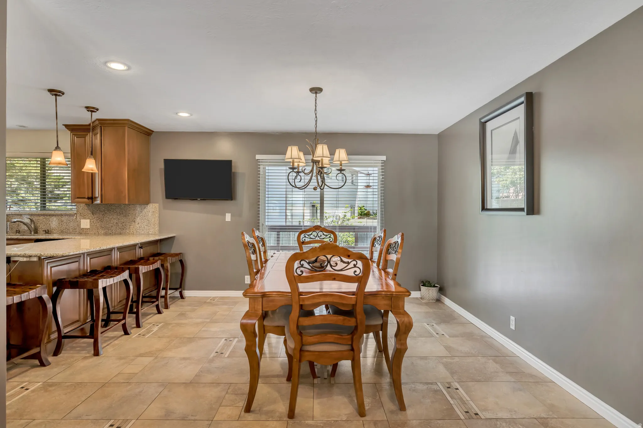 Dining area featuring tile flooring, a chandelier, and a window with blinds