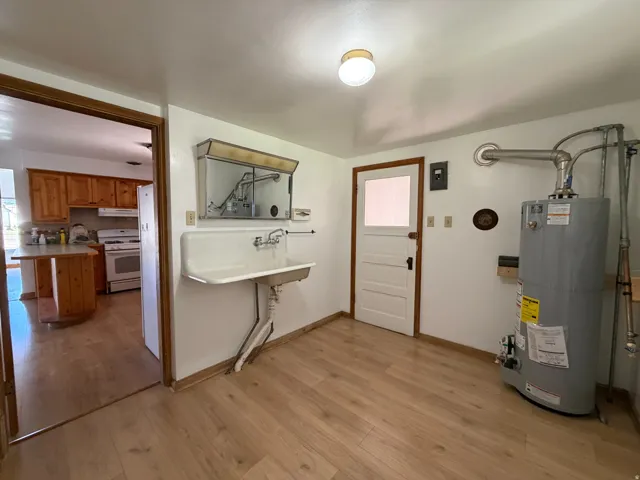 Utility room with wood-finish flooring and a wall-mounted sink
