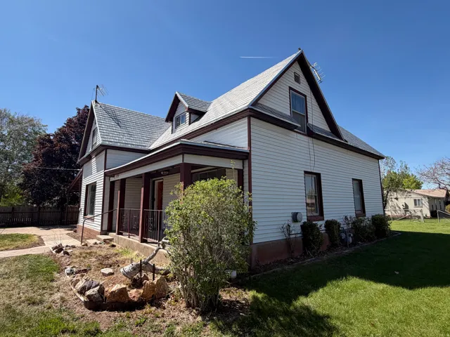 Two-story residence featuring white siding and dark trim