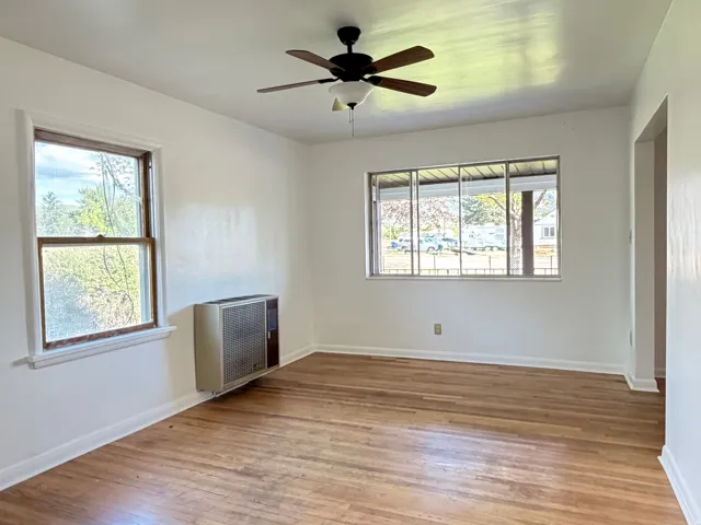 Family room with wood floors and a wall heater.